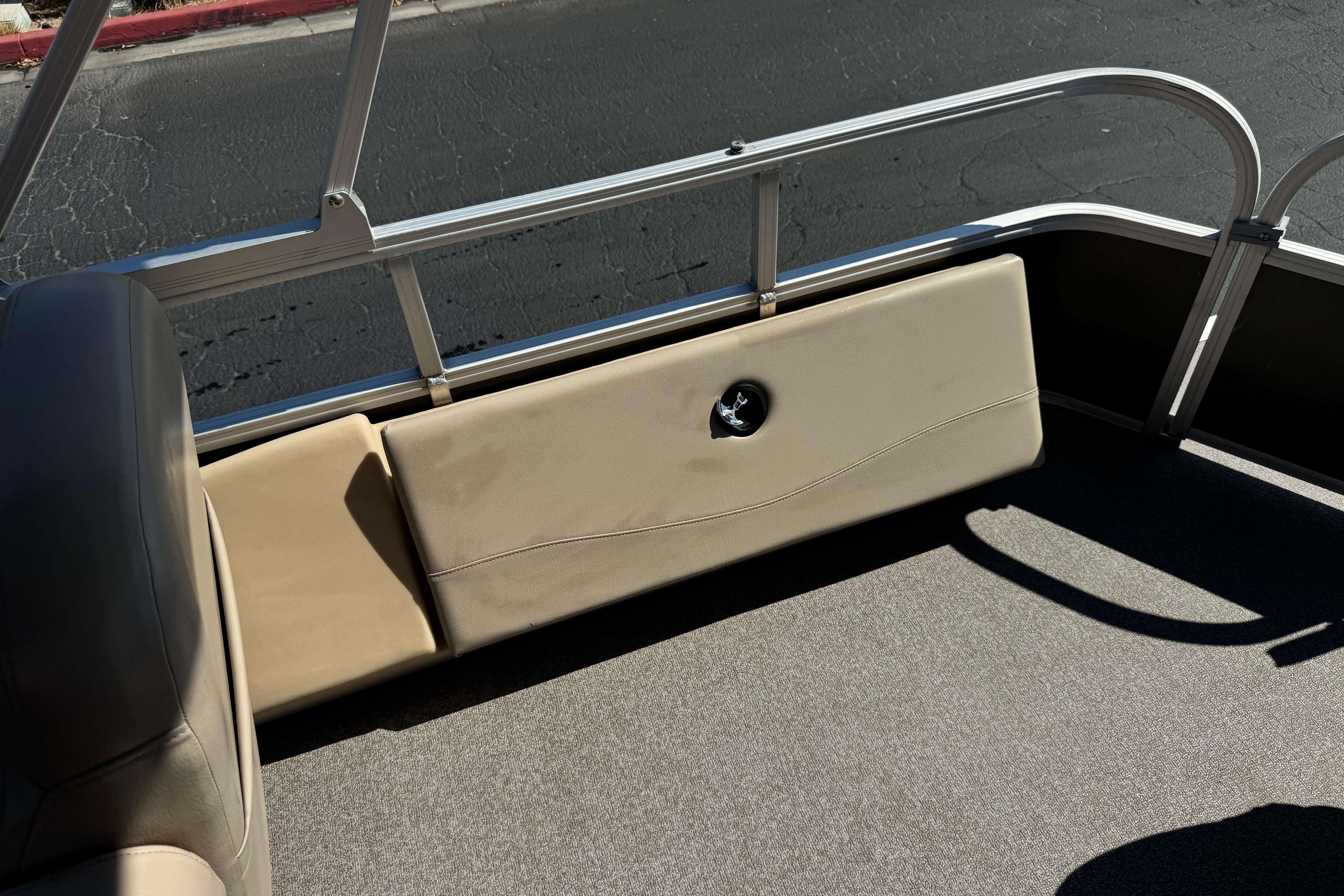 Interior view of a 2018 Sun Tracker SportFish 22 DLX pontoon boat with beige seating.