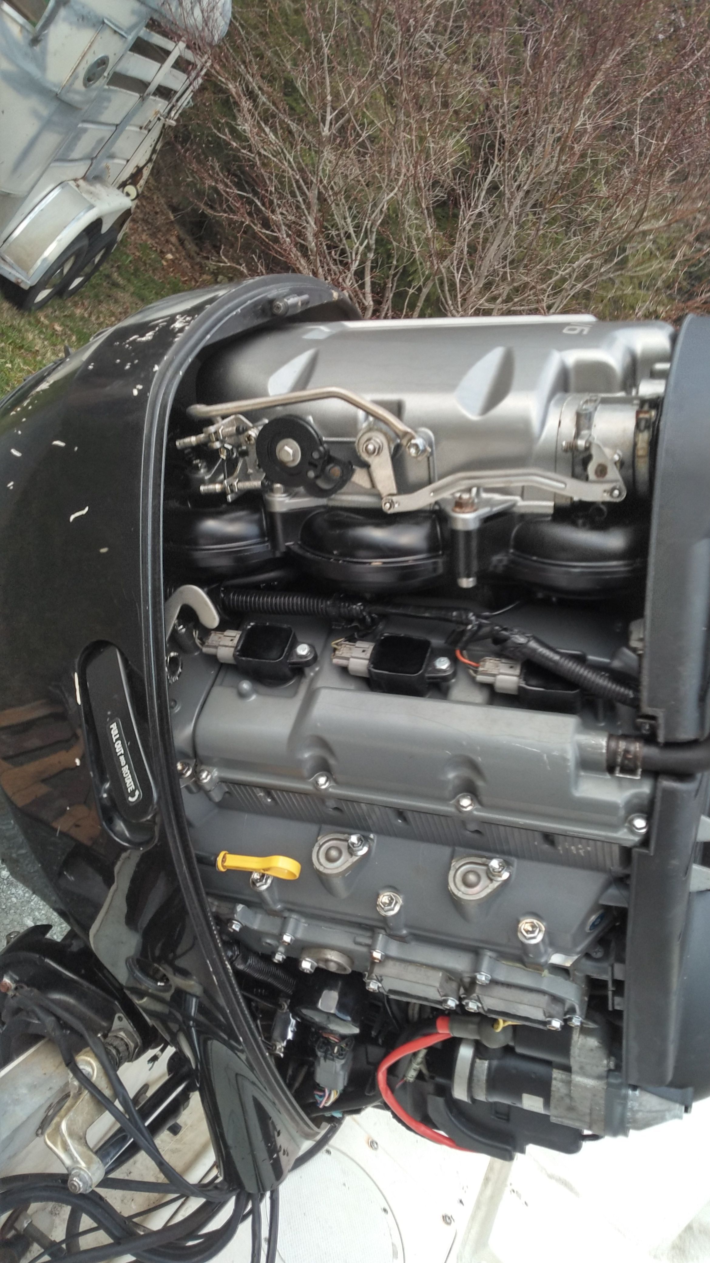 An outboard motor of a boat with visible mechanical parts and cables.