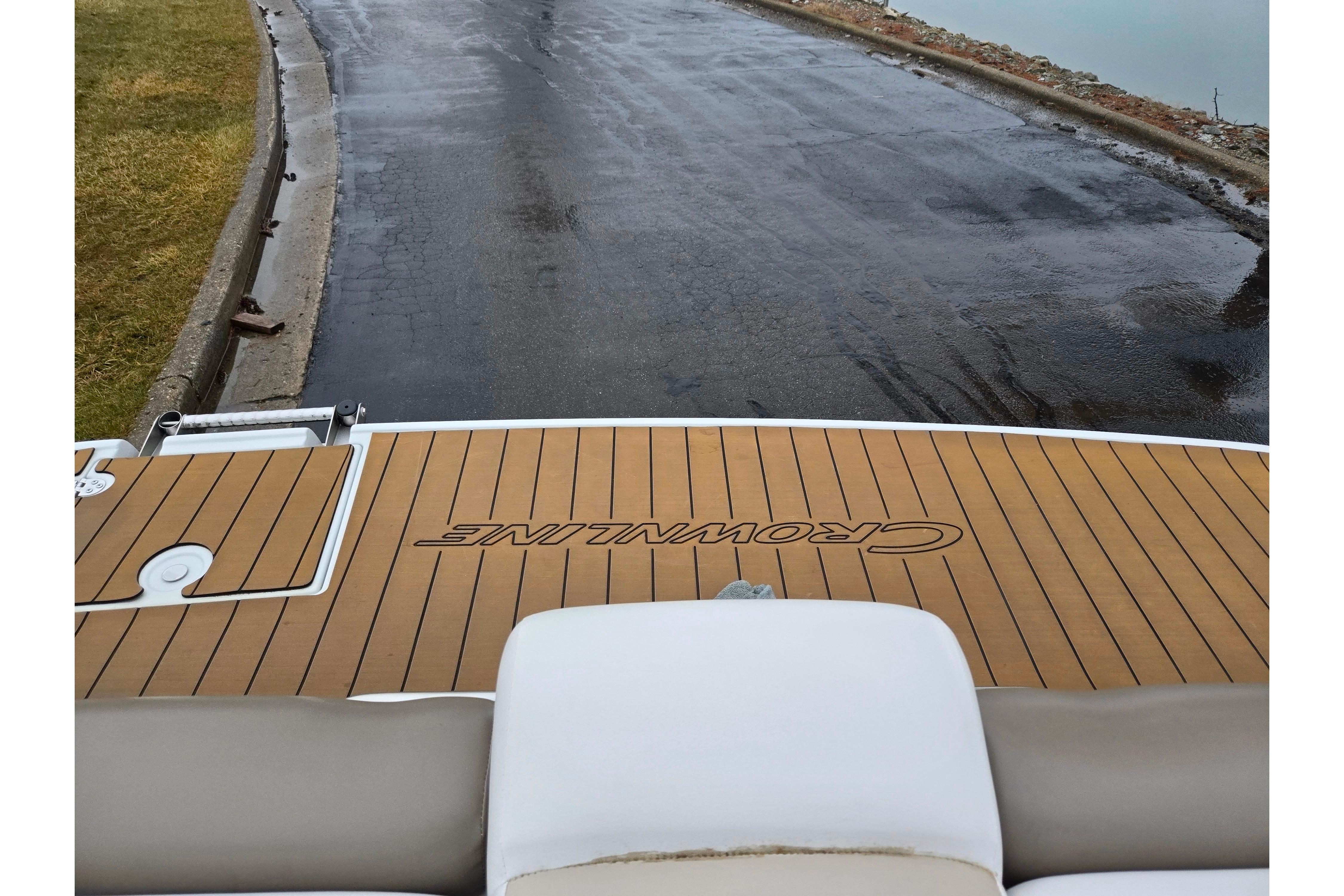 2012 Crownline 235 SS boat with teak deck, near wet pavement and water.