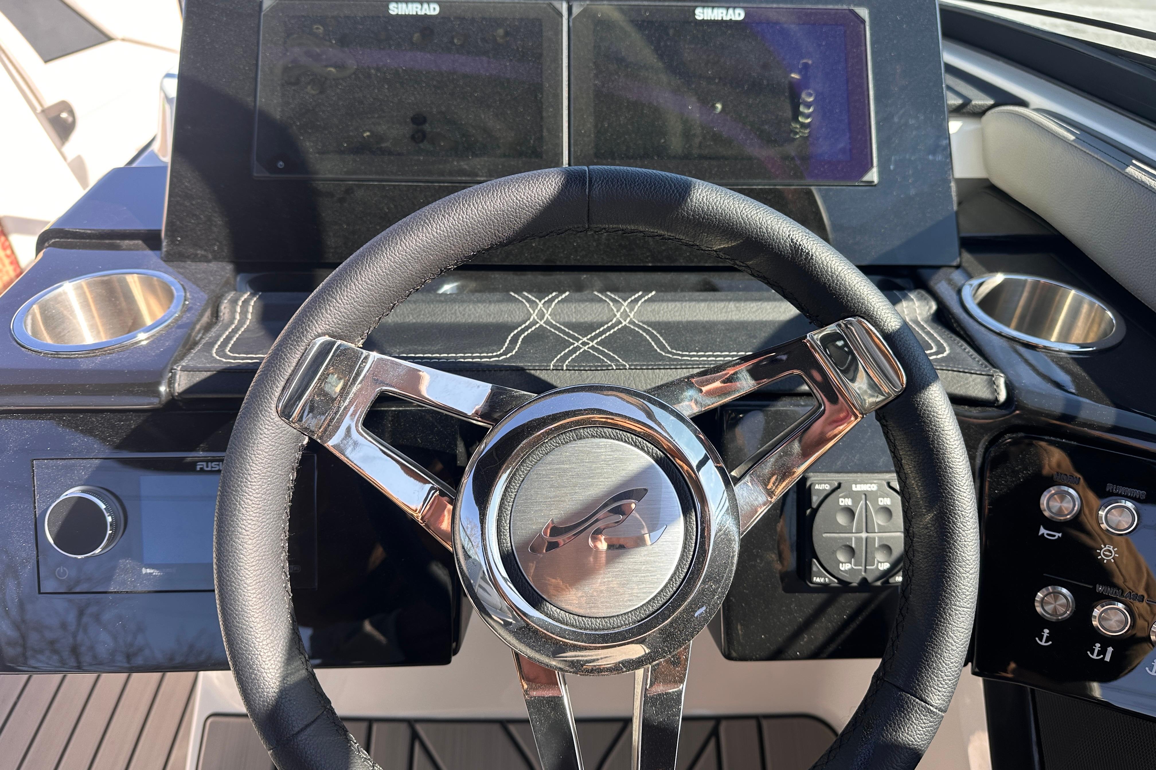 Steering wheel and dashboard of 2026 Sea Ray SLX 260 Outboard boat with Simrad displays.