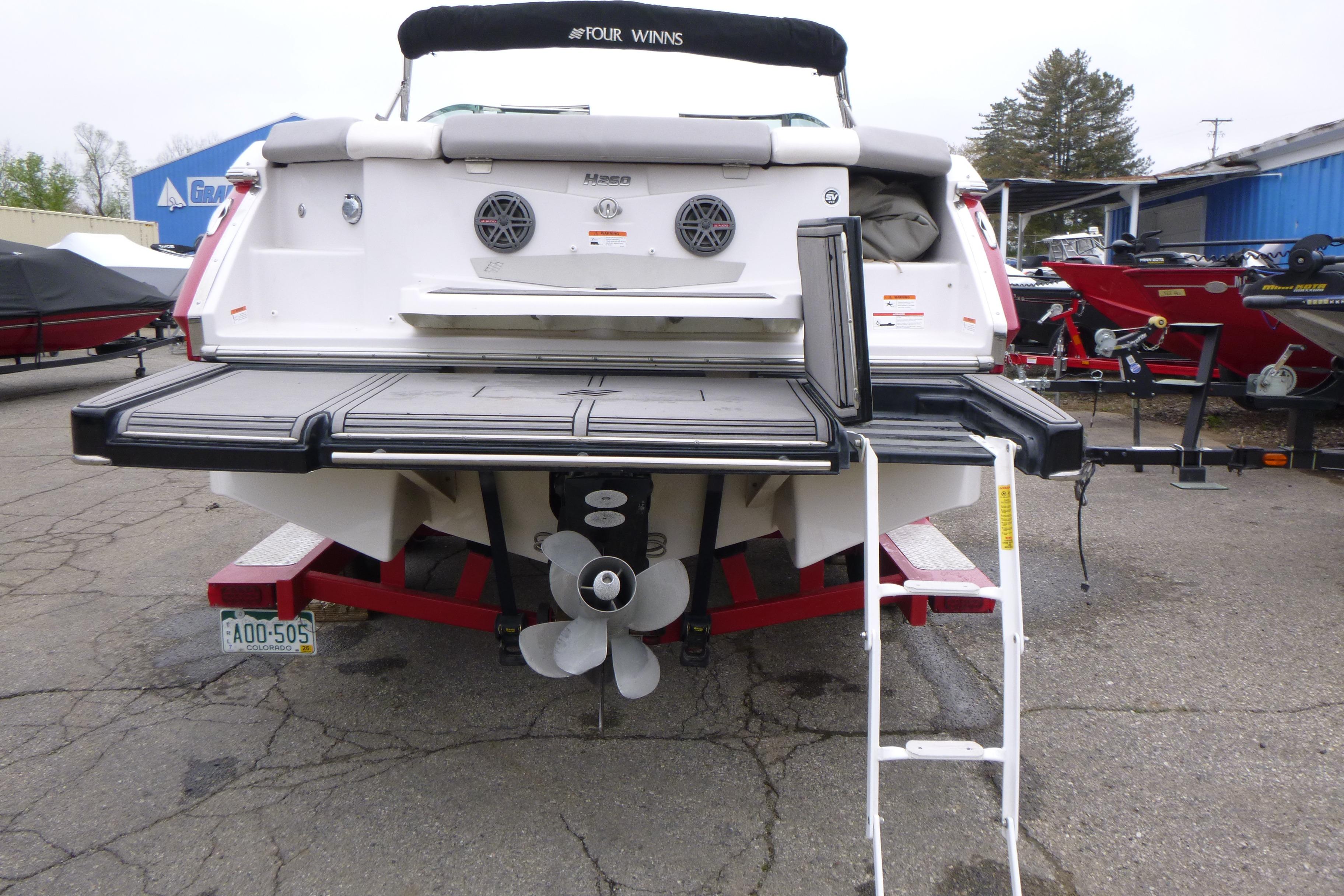 Rear view of 2017 Four Winns H260 boat with swim platform and ladder.