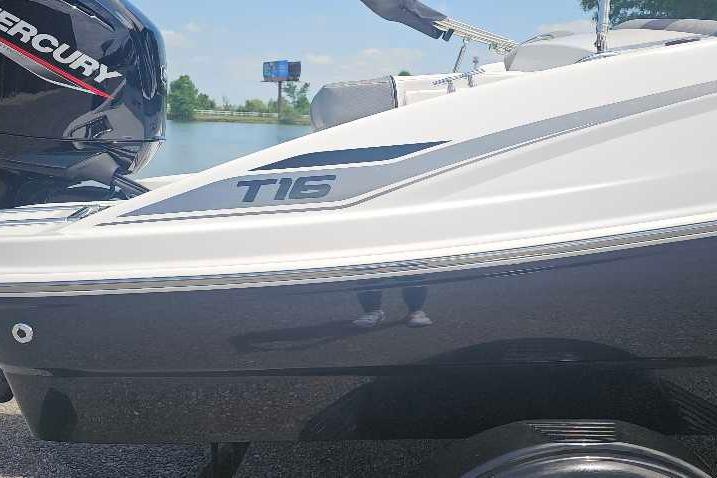 2026 Tahoe T16 boat with Mercury engine, parked near a lake.
