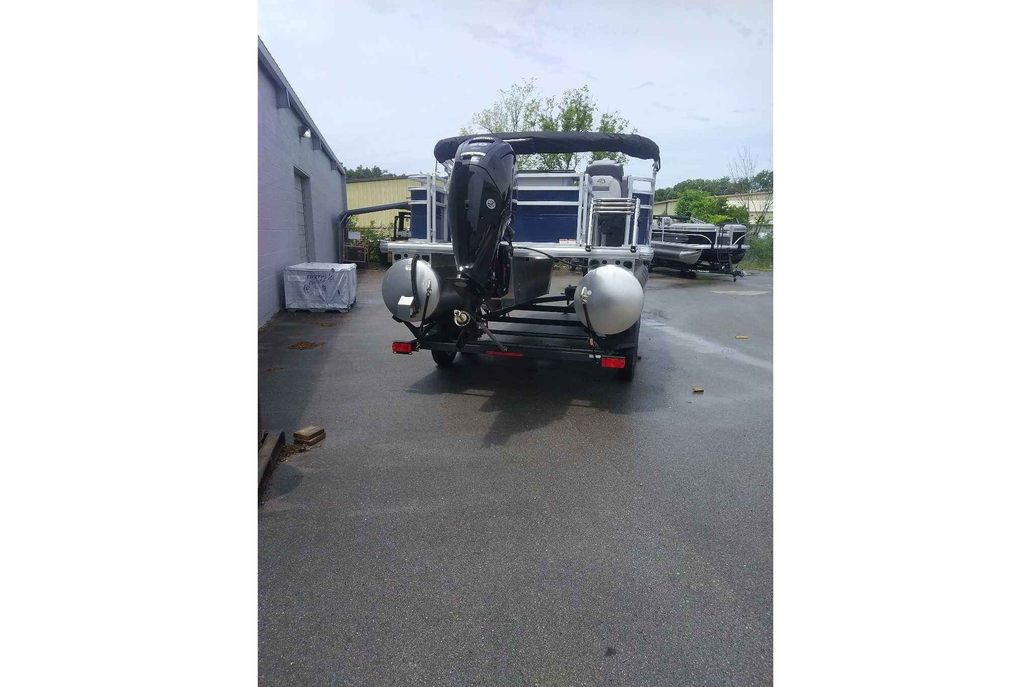 2026 Sun Tracker SportFish 20 DLX pontoon boat, rear view, parked outdoors.