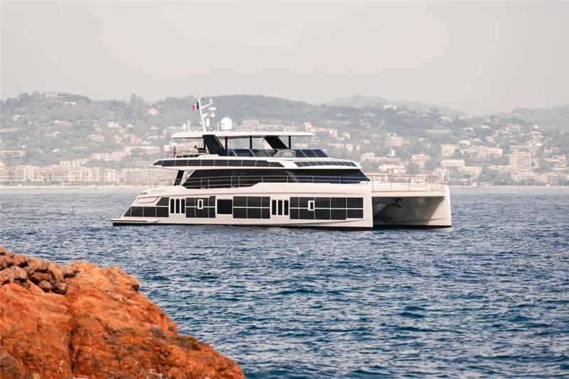 2026 Sunreef 80 Sunreef Power yacht cruising near rocky coastline.