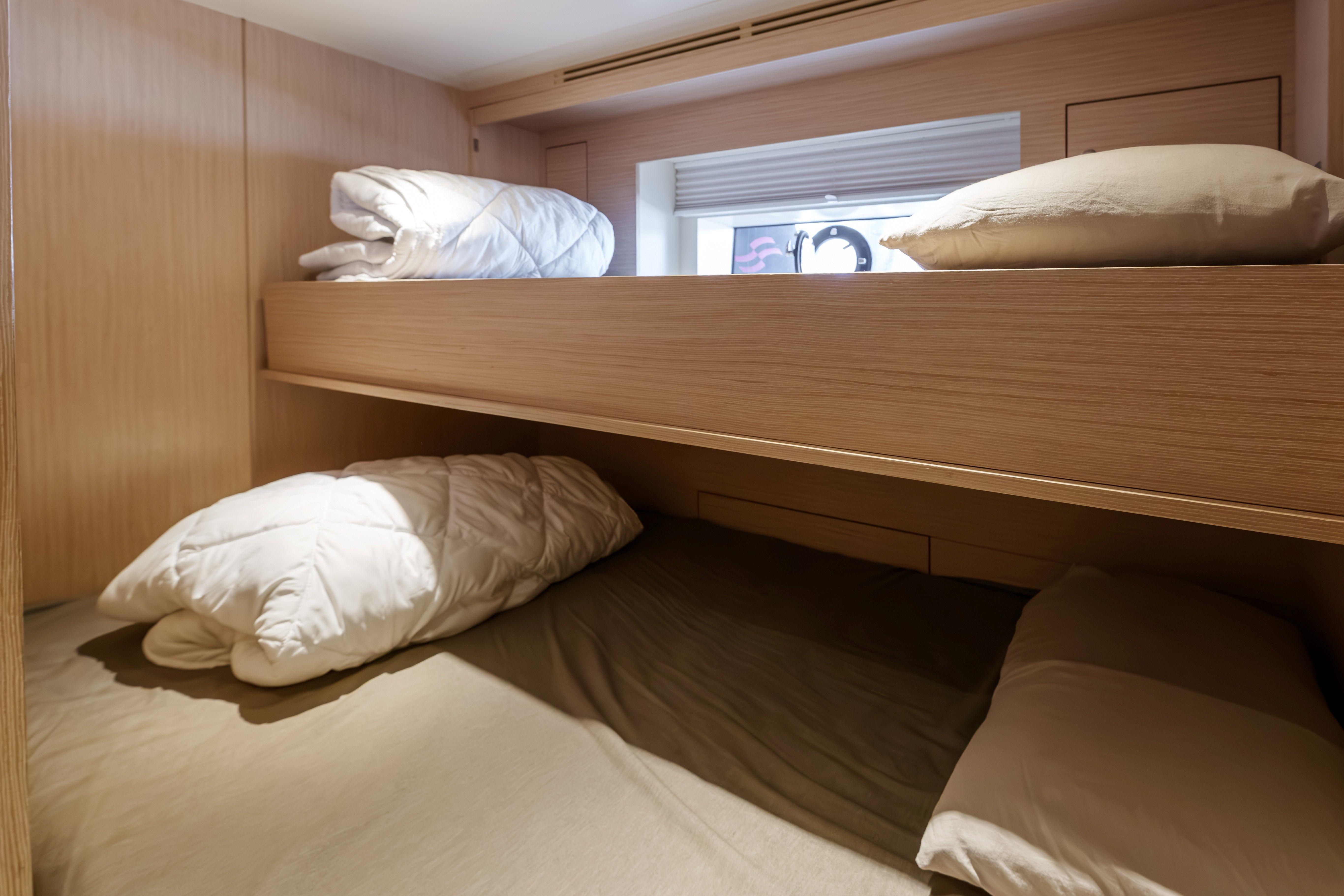 Bunk beds in 2024 Sirena 88 yacht cabin with wooden finish and cozy bedding.