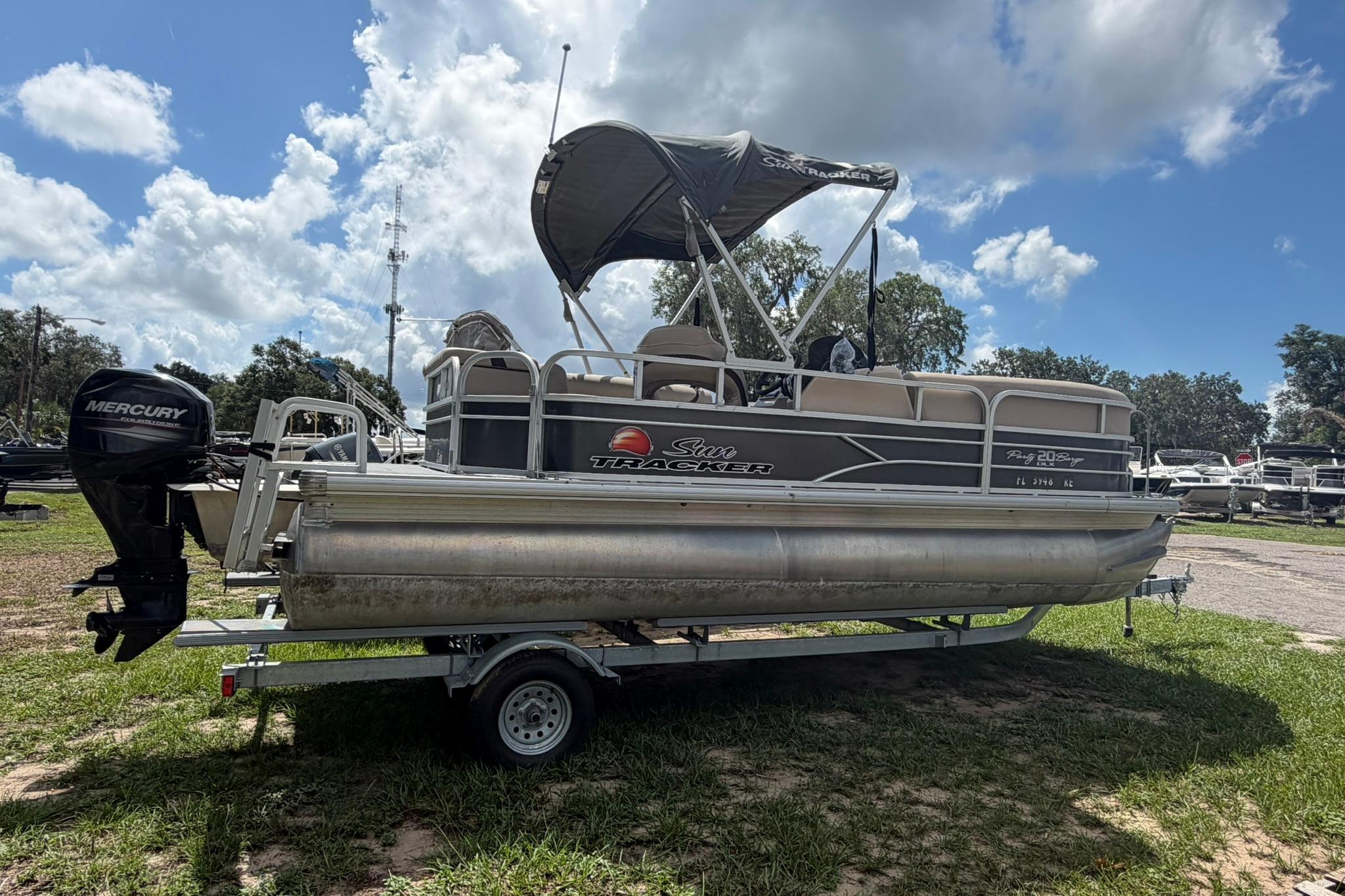 2016 SUNTRACKER Party Barge 20 pontoon boat on trailer, with Mercury outboard motor.