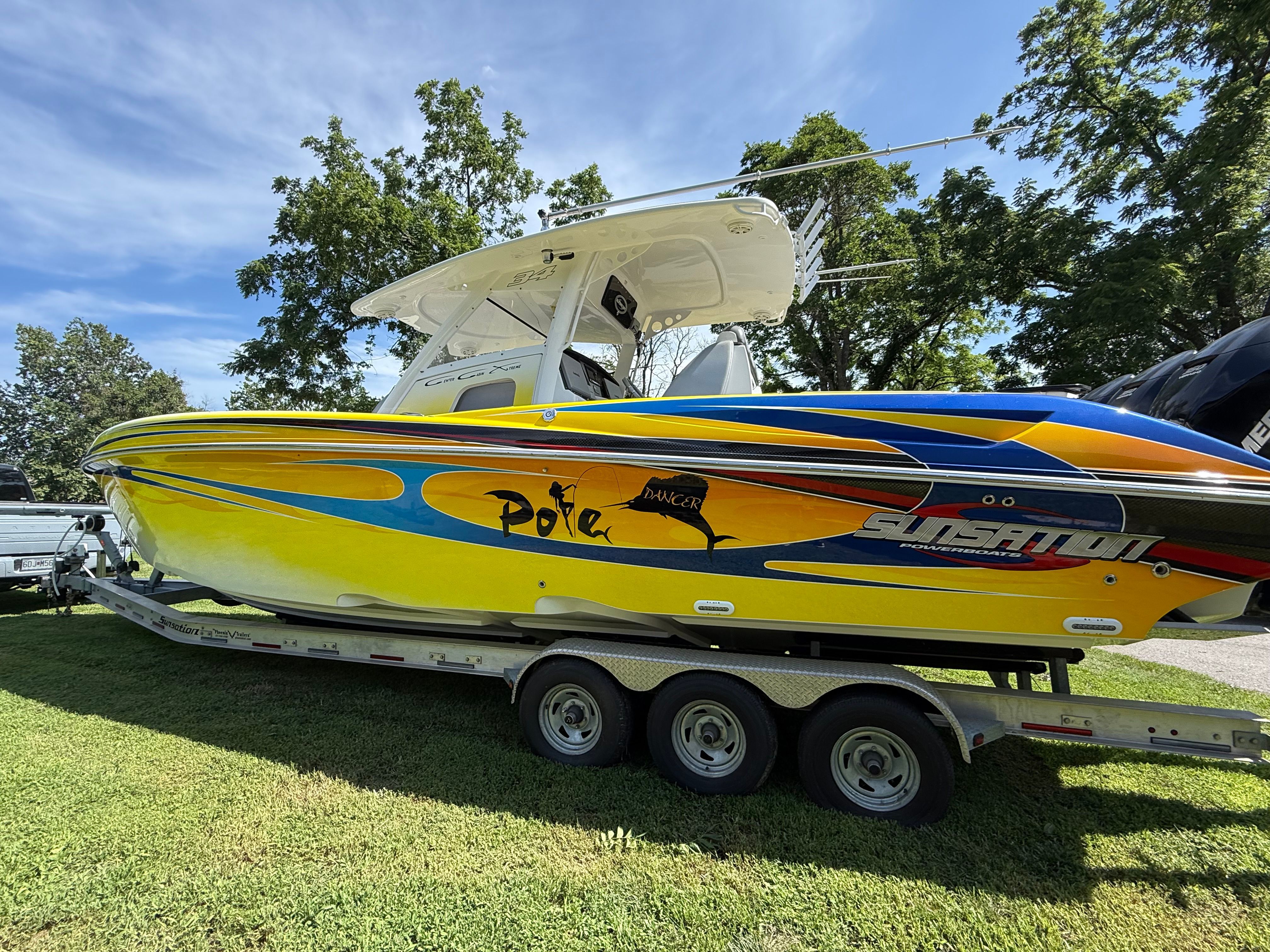 A yellow 2014 Sunsation 34 CCX on a trailer on grass.