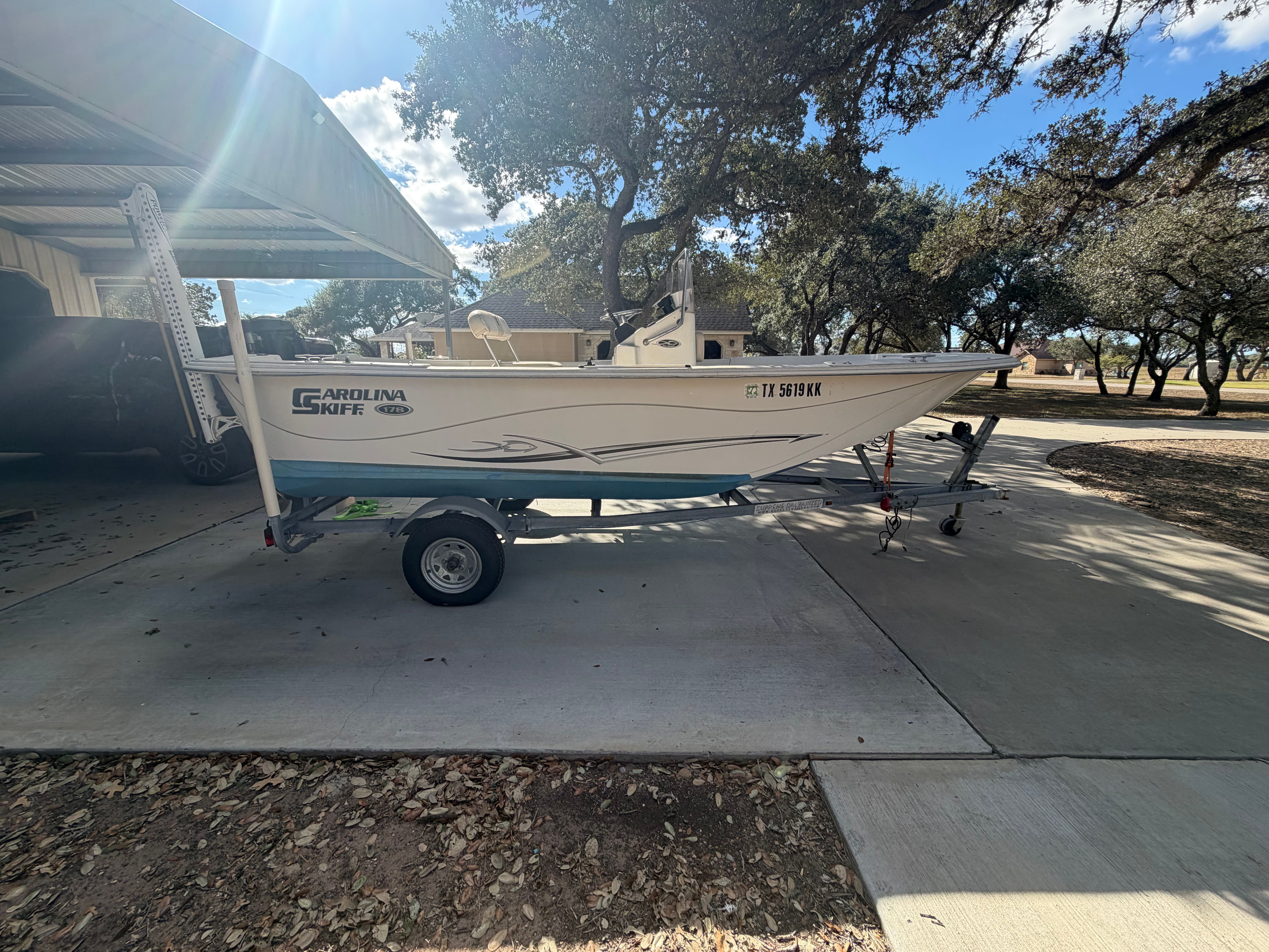 A 2016 Carolina Skiff 178 DLV on a trailer under a carport.