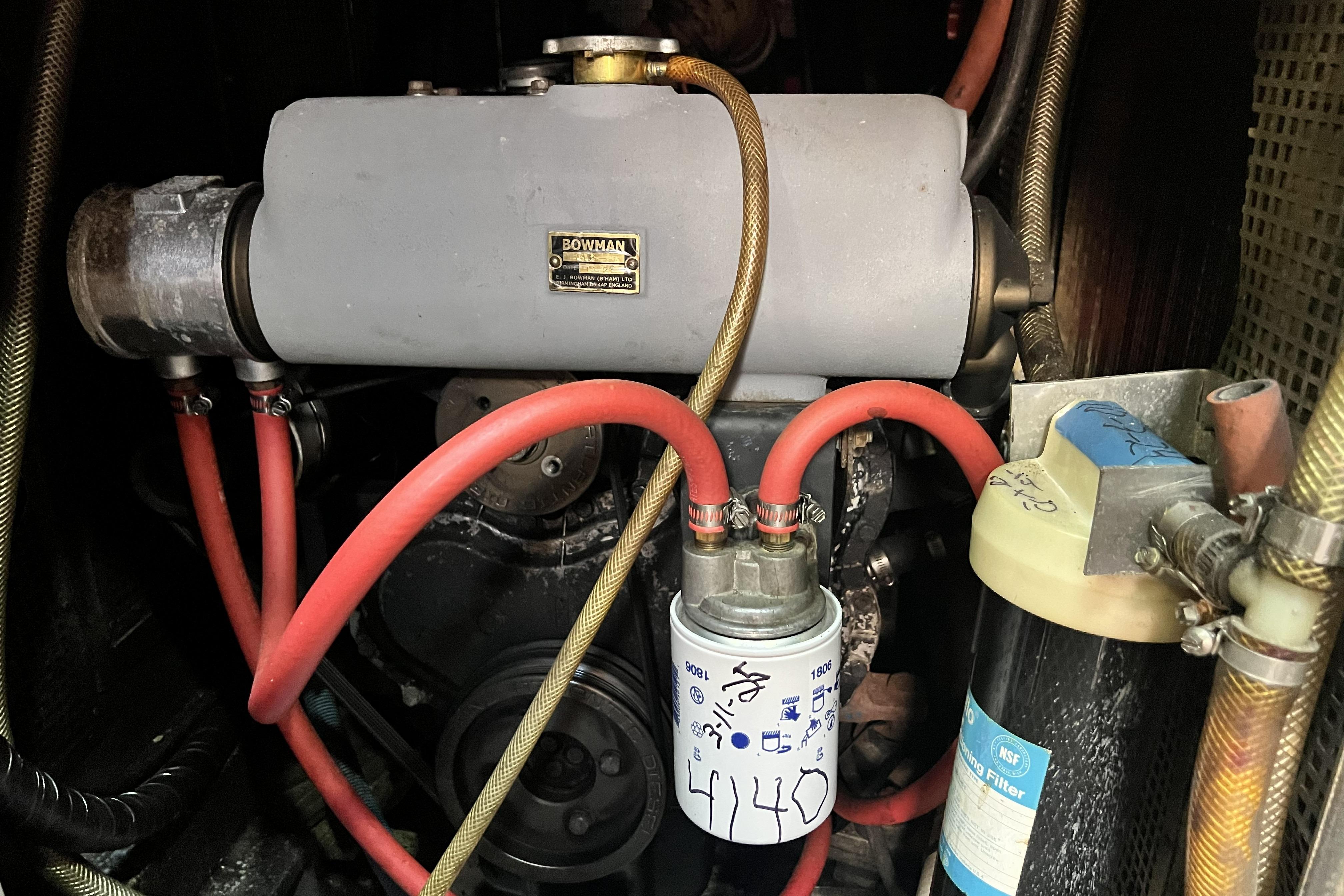 Engine compartment of a 1985 Pinical 14-34 with visible hoses and filters.