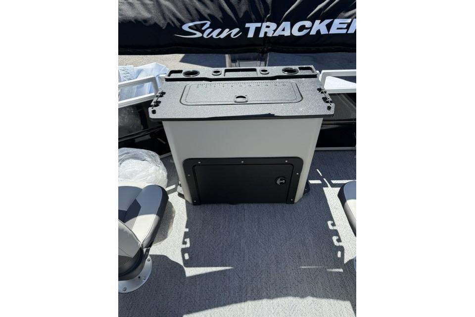 2026 Sun Tracker Fishin' Barge 20 DLX interior with storage compartment and seating.