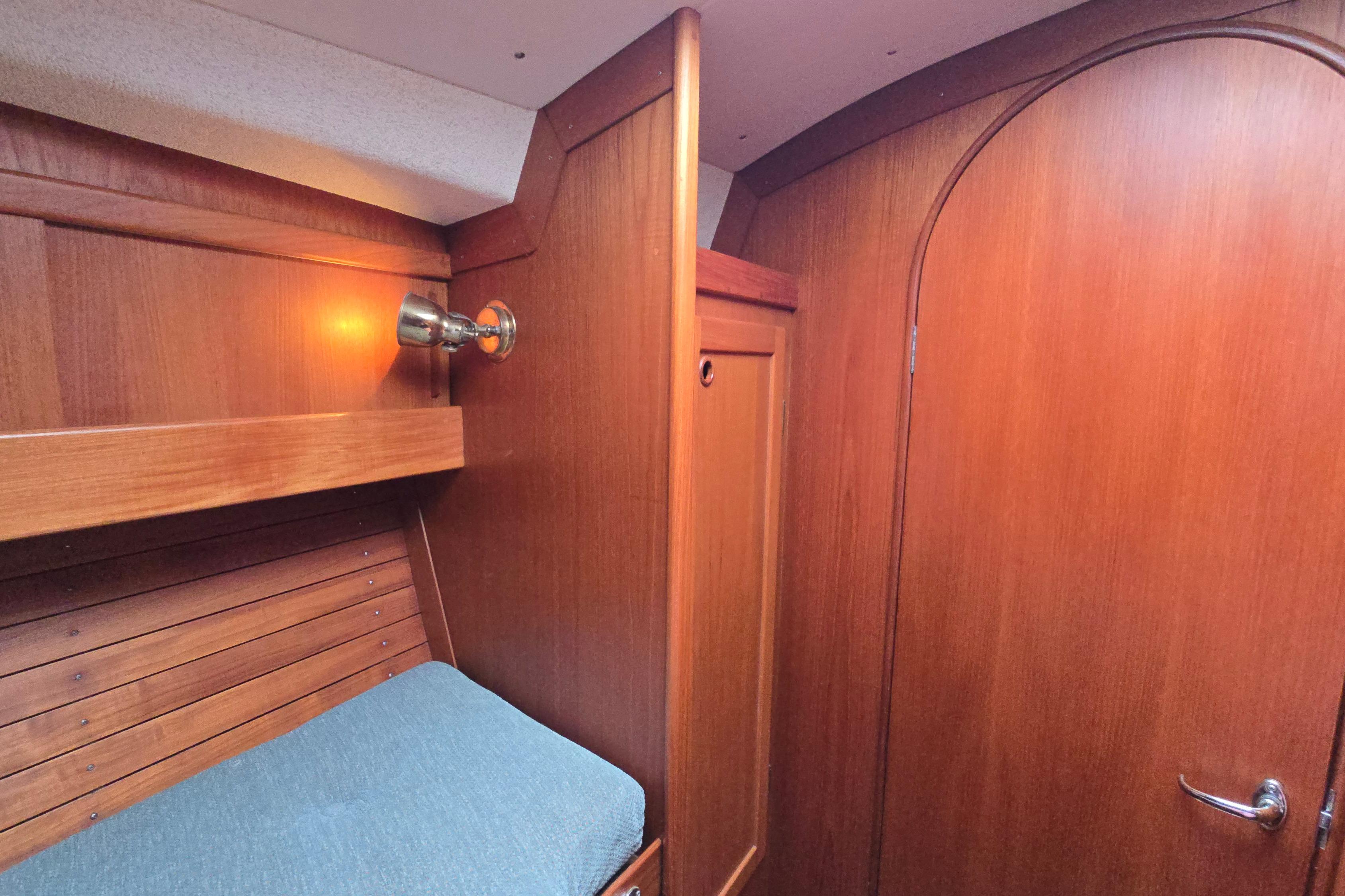 Cabin interior of 1991 Finngulf 36 yacht with wooden paneling and cozy lighting.