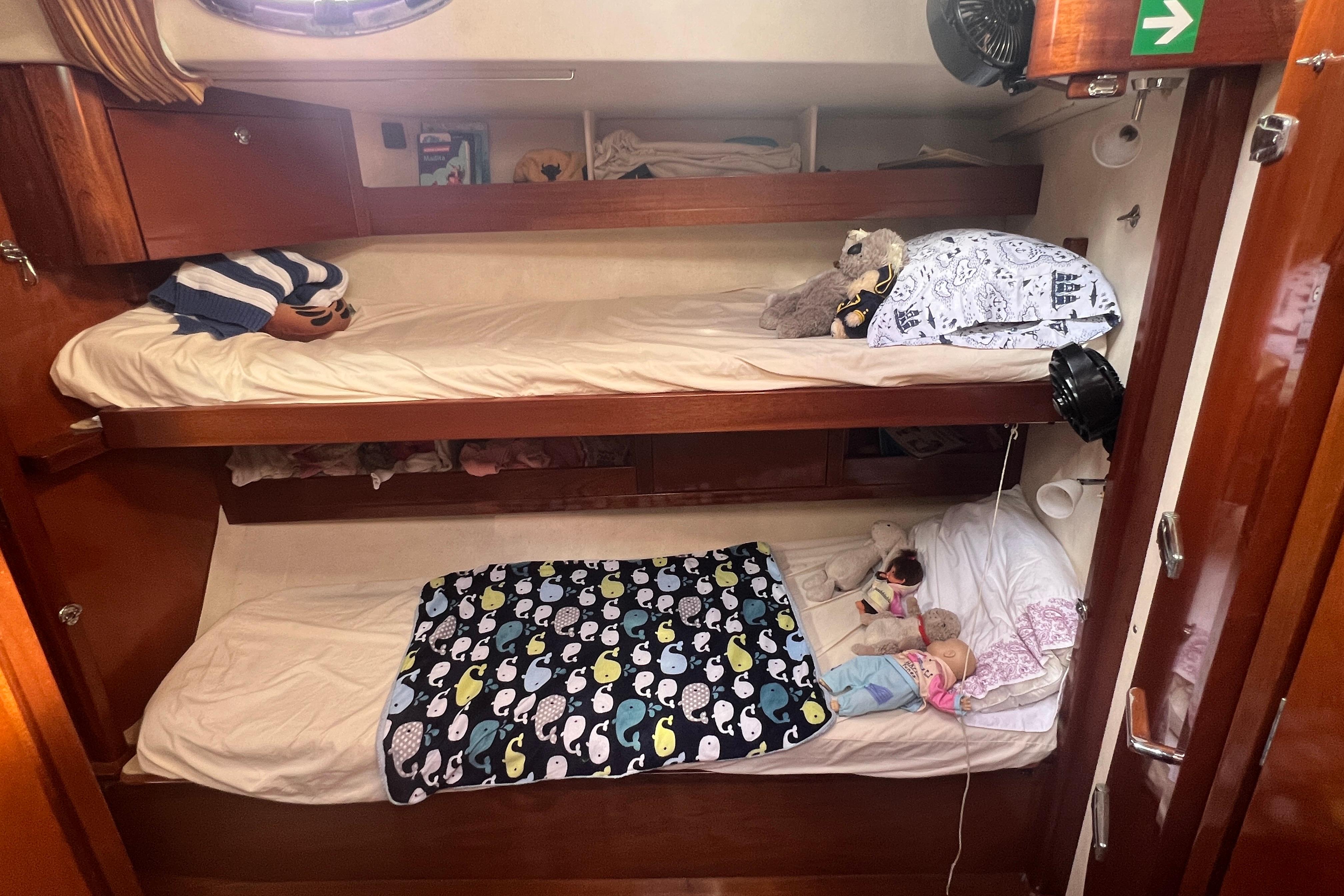 Cozy bunk beds in a 2005 Amel 54 yacht cabin with plush toys and colorful bedding.