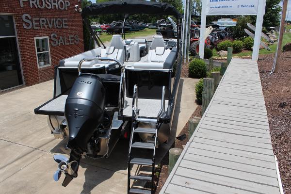 2025 Tahoe Pontoon Cascade Quad Lounger at dealership, rear view with outboard motor.