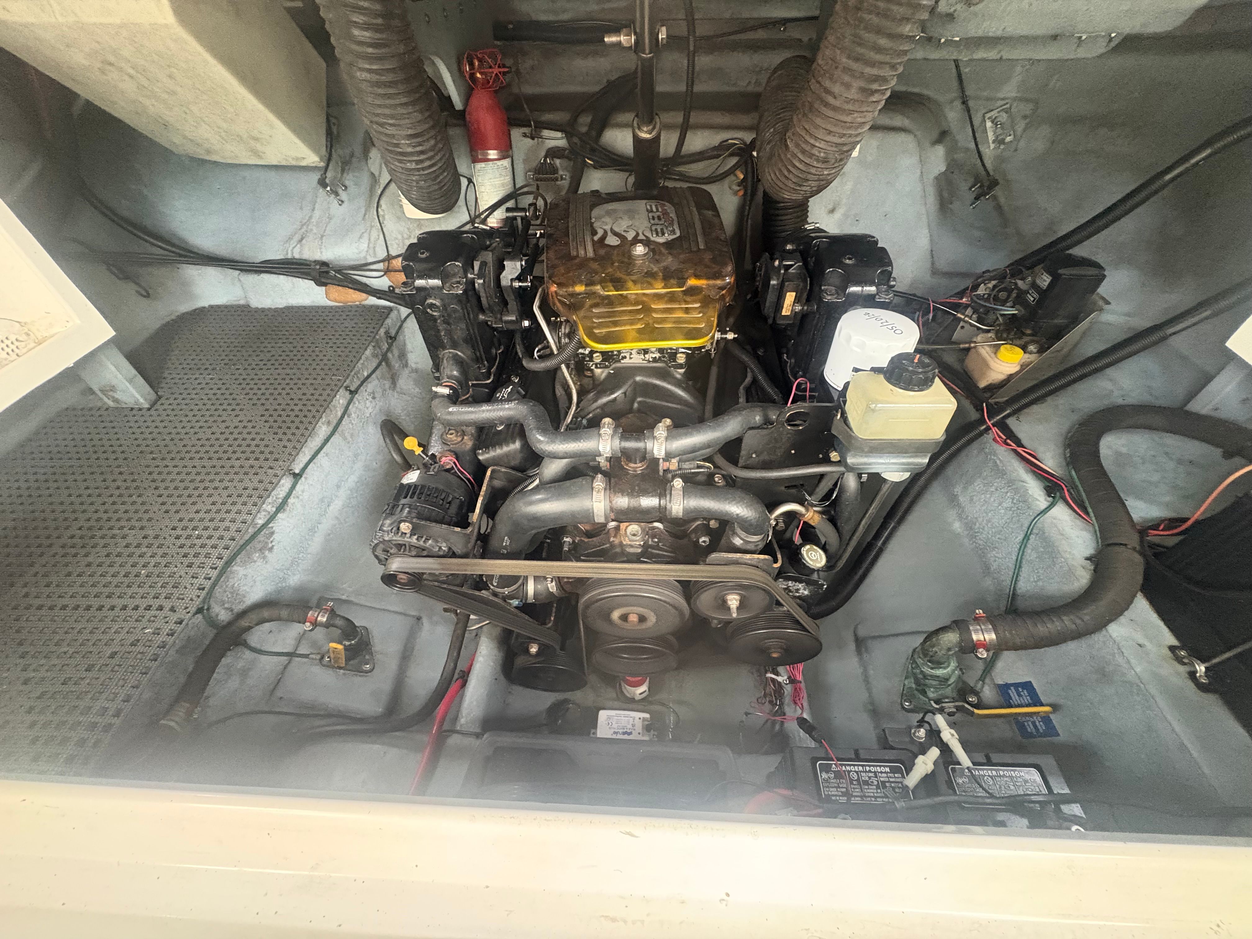 Engine compartment of a 1996 Sea Ray 280 Cuddy Cabin with visible engine and wiring.