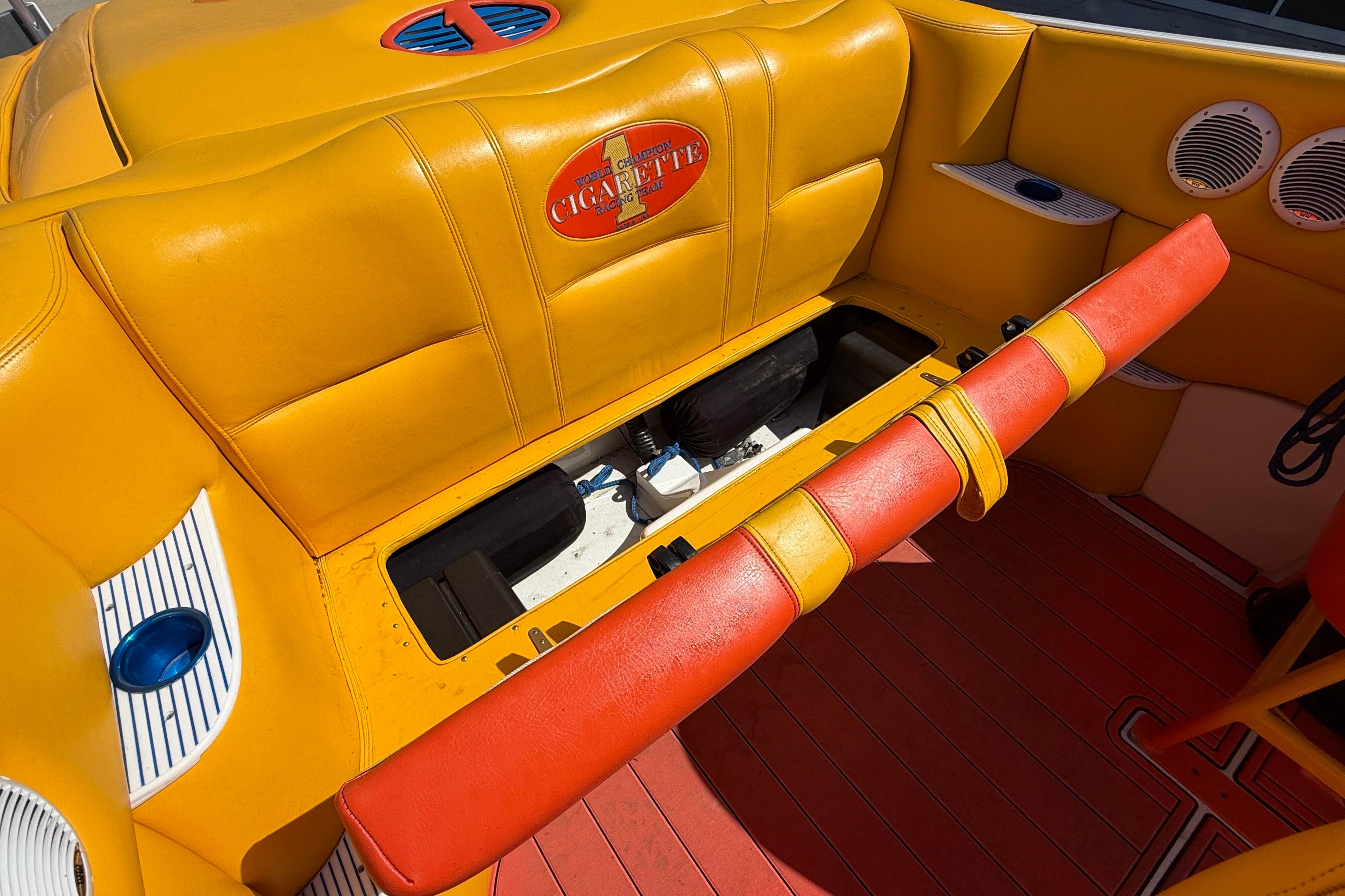 2002 Cigarette 35' Cafe Racer boat interior with vibrant yellow and red seating.