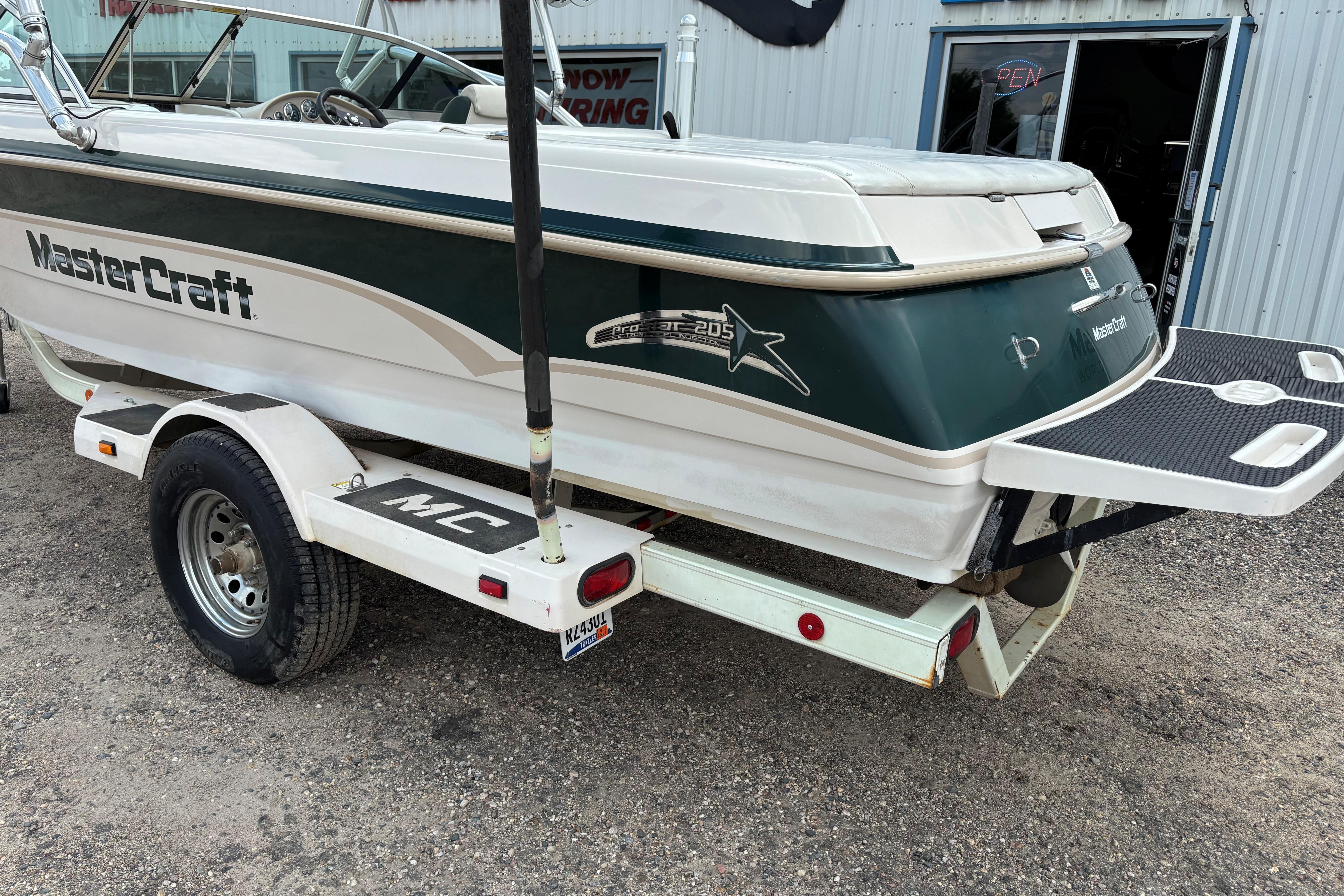1999 MasterCraft 205 PRO STAR boat on trailer, parked outside a building.