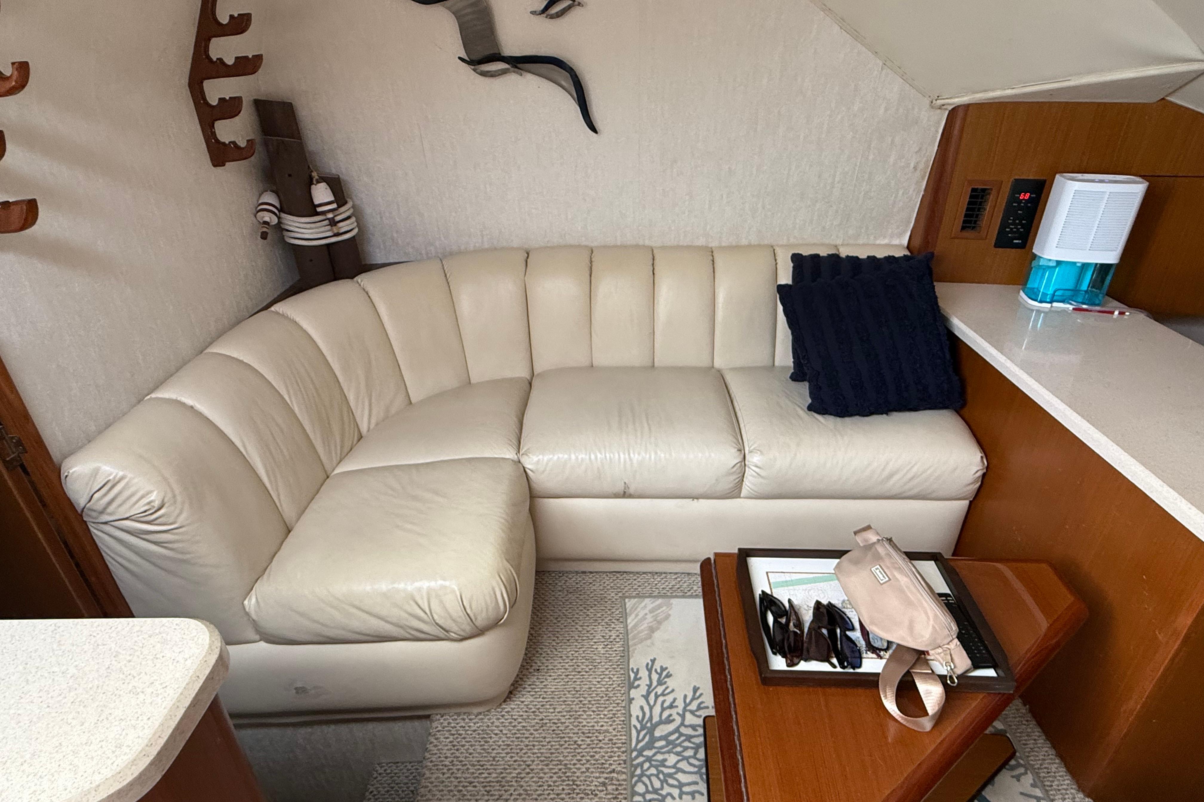 Interior of 1999 Ocean Yachts 40 Express with cream leather sofa and wooden accents.