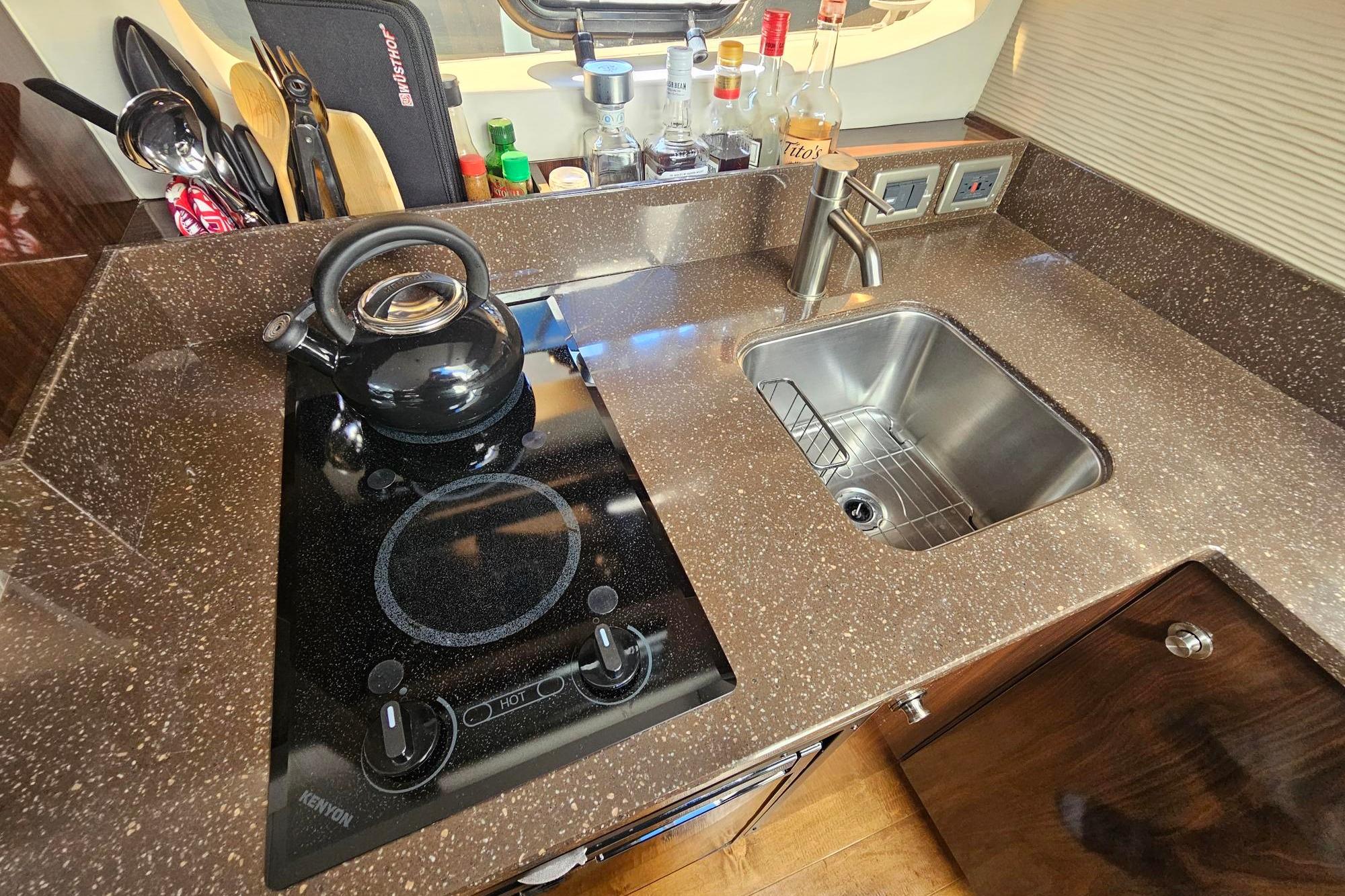 Modern galley kitchen in 2016 Sea Ray Sundancer 350 yacht with stove and sink.