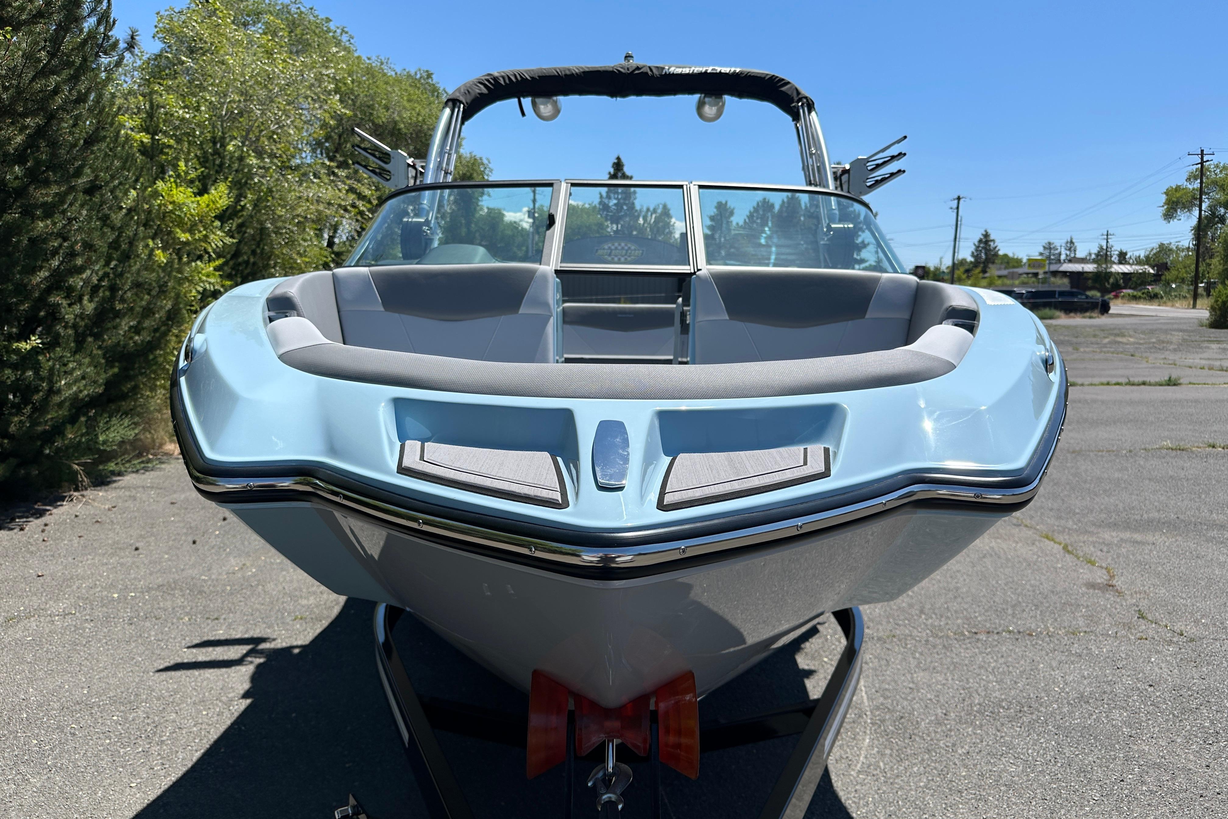 2023 MasterCraft NXT23 boat, light blue, parked outdoors on a sunny day.