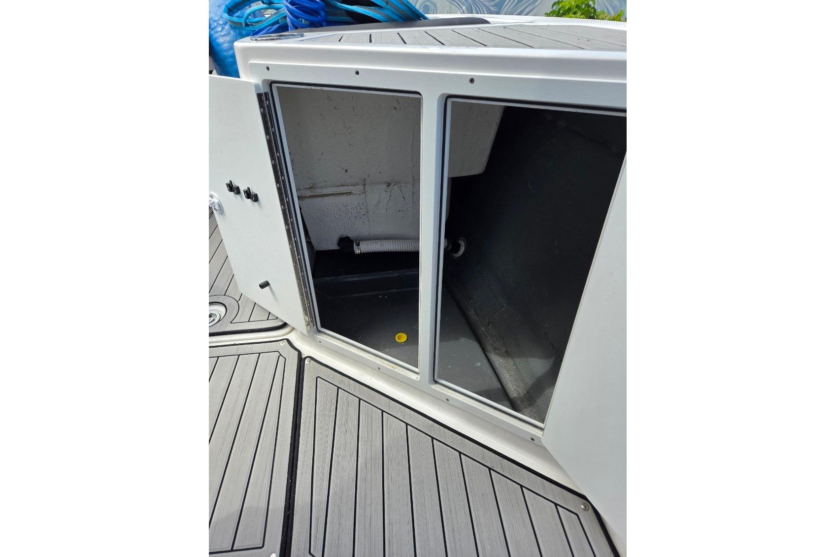 Open storage compartment on 2024 Yamaha Boats 222 FSH Sport E, featuring sleek deck design.