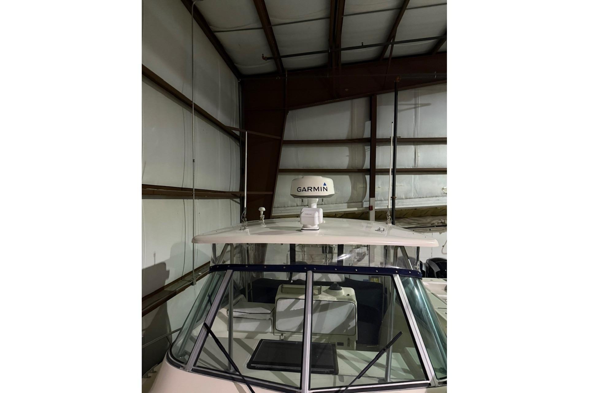 2000 Pursuit 3070 Offshore Center Console boat with Garmin radar in storage.