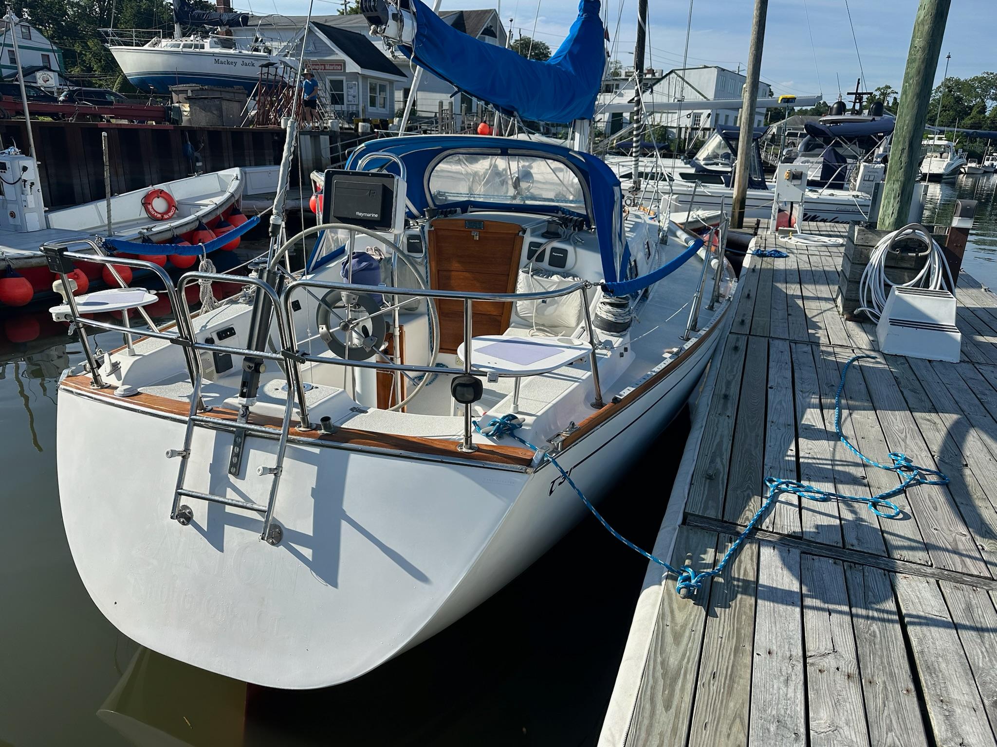 1988 Tartan 31 sailboat docked at marina, featuring blue sail cover and wooden accents.