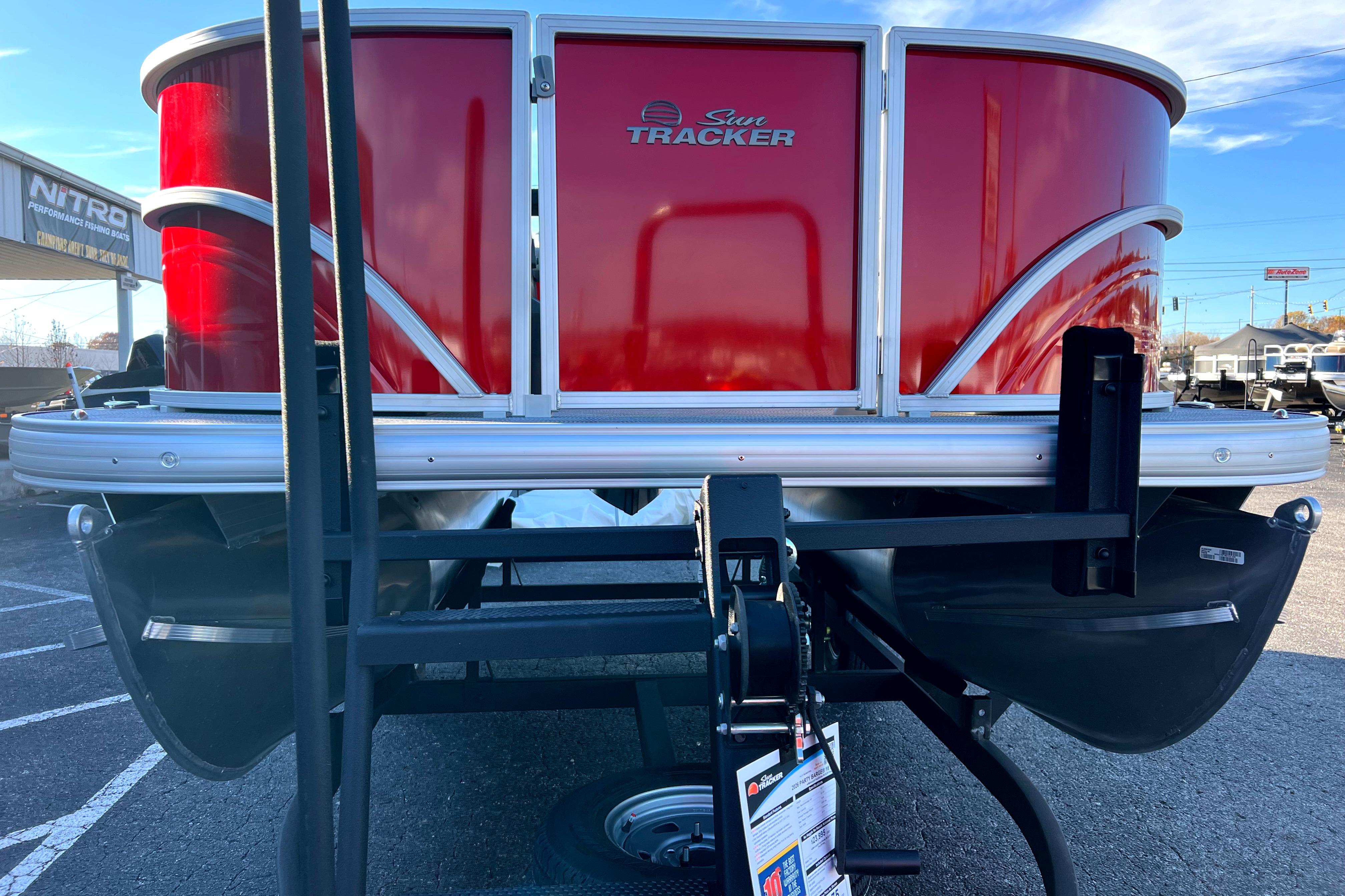 2026 Sun Tracker Party Barge 16 DLX pontoon boat, red exterior, on trailer.