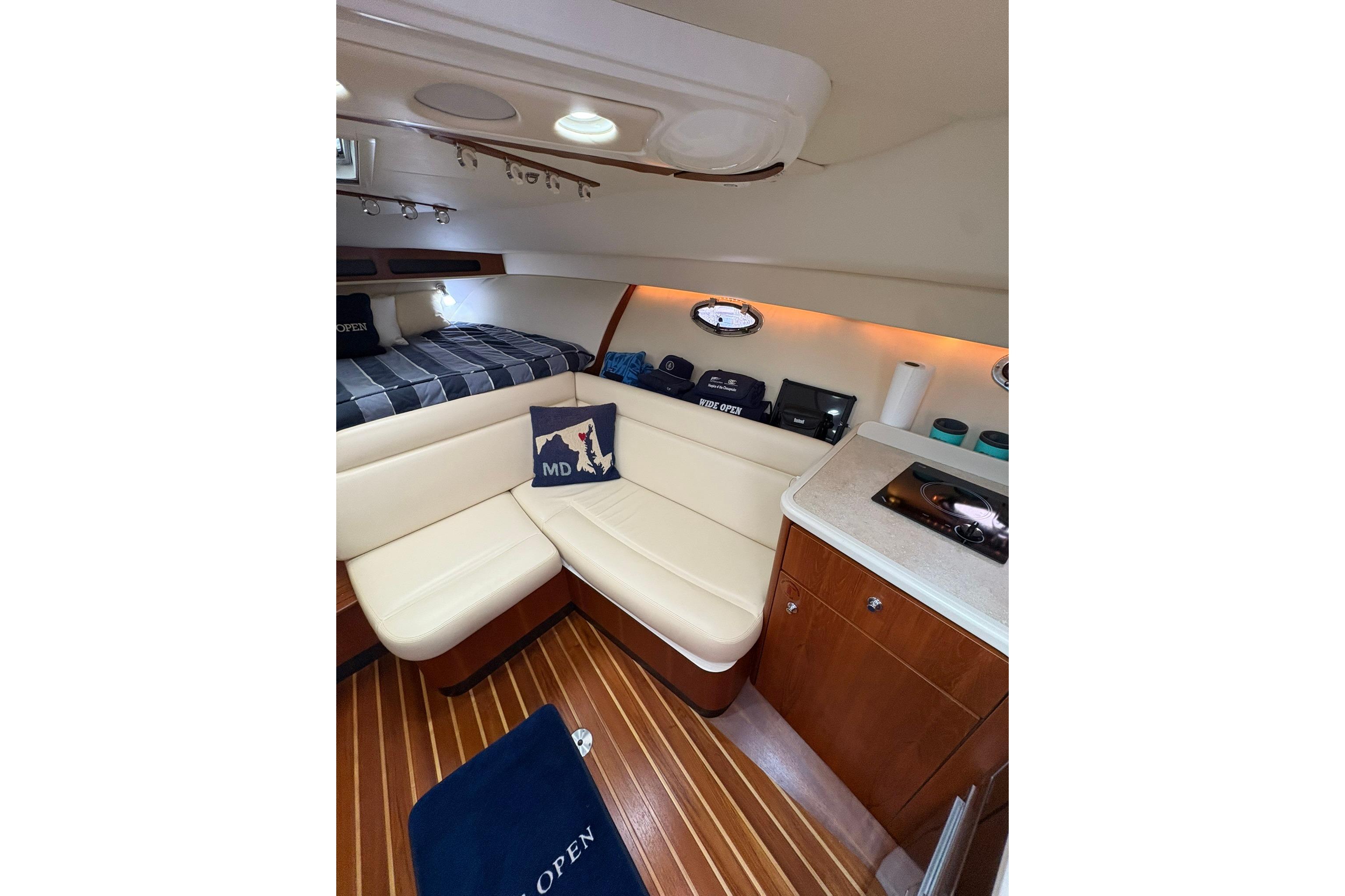 2008 Tiara Yachts 3000 Open cabin interior with seating, bed, and kitchenette.