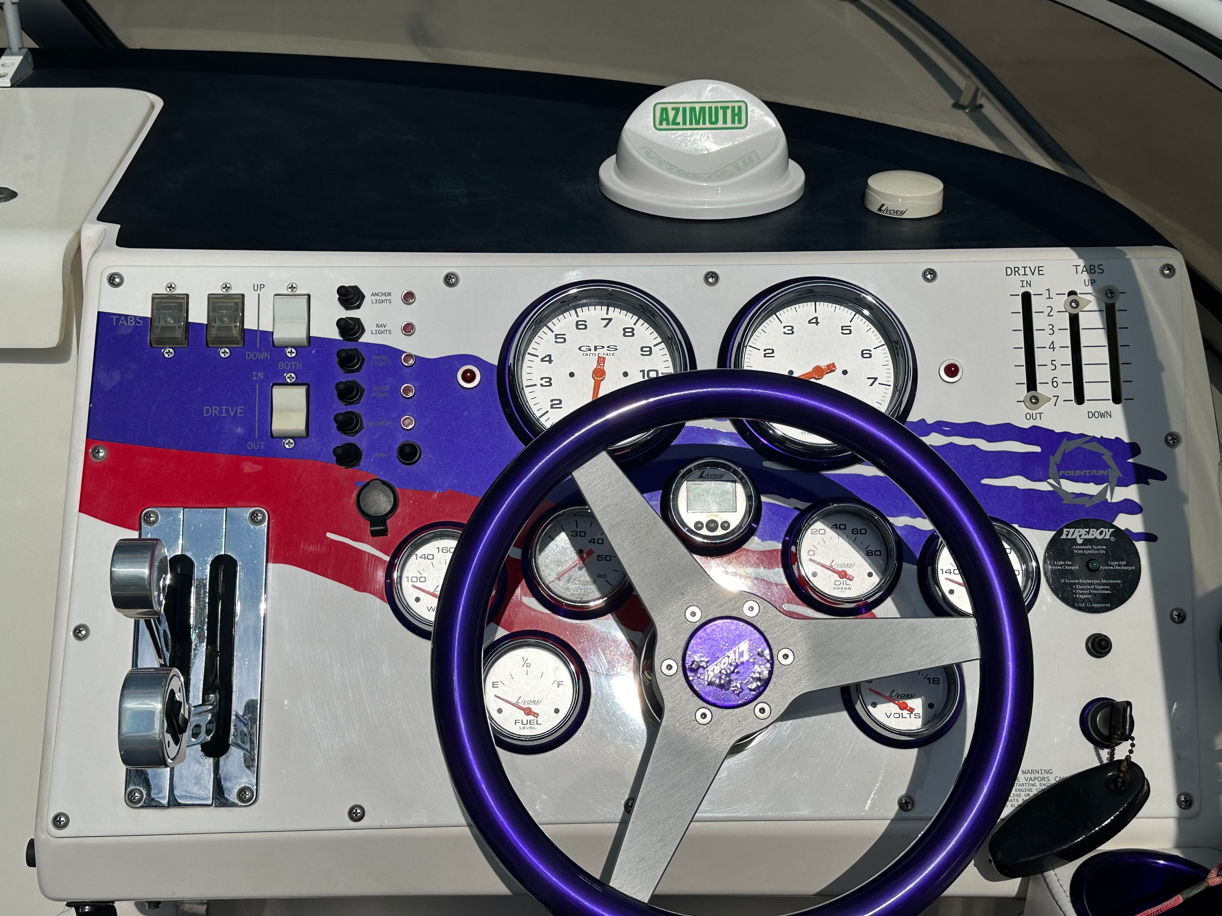 Dashboard of a 2006 Fountain 29 Fever with purple steering wheel and various gauges.