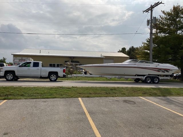 2001 Fountain Lightning boat on trailer behind white truck.