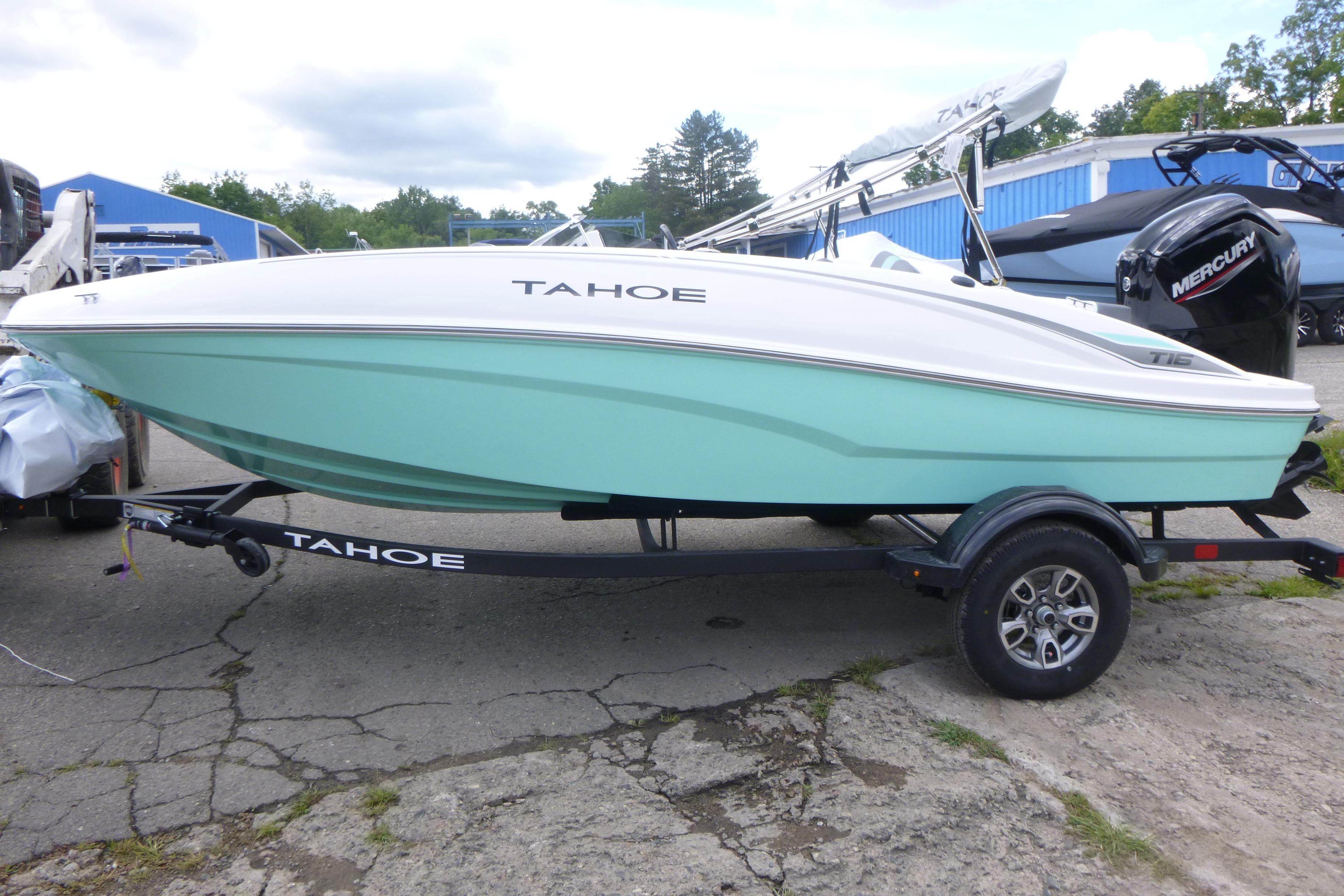 2026 Tahoe T16 boat on trailer, mint green hull, parked outdoors.
