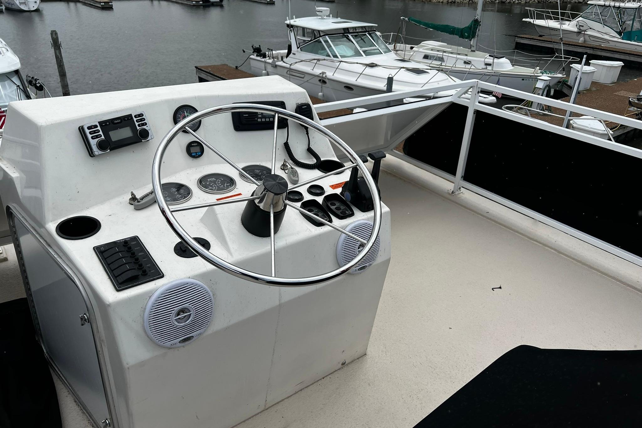 Flybridge helm of 2010 Skipperliner 480, featuring steering wheel and control panel.