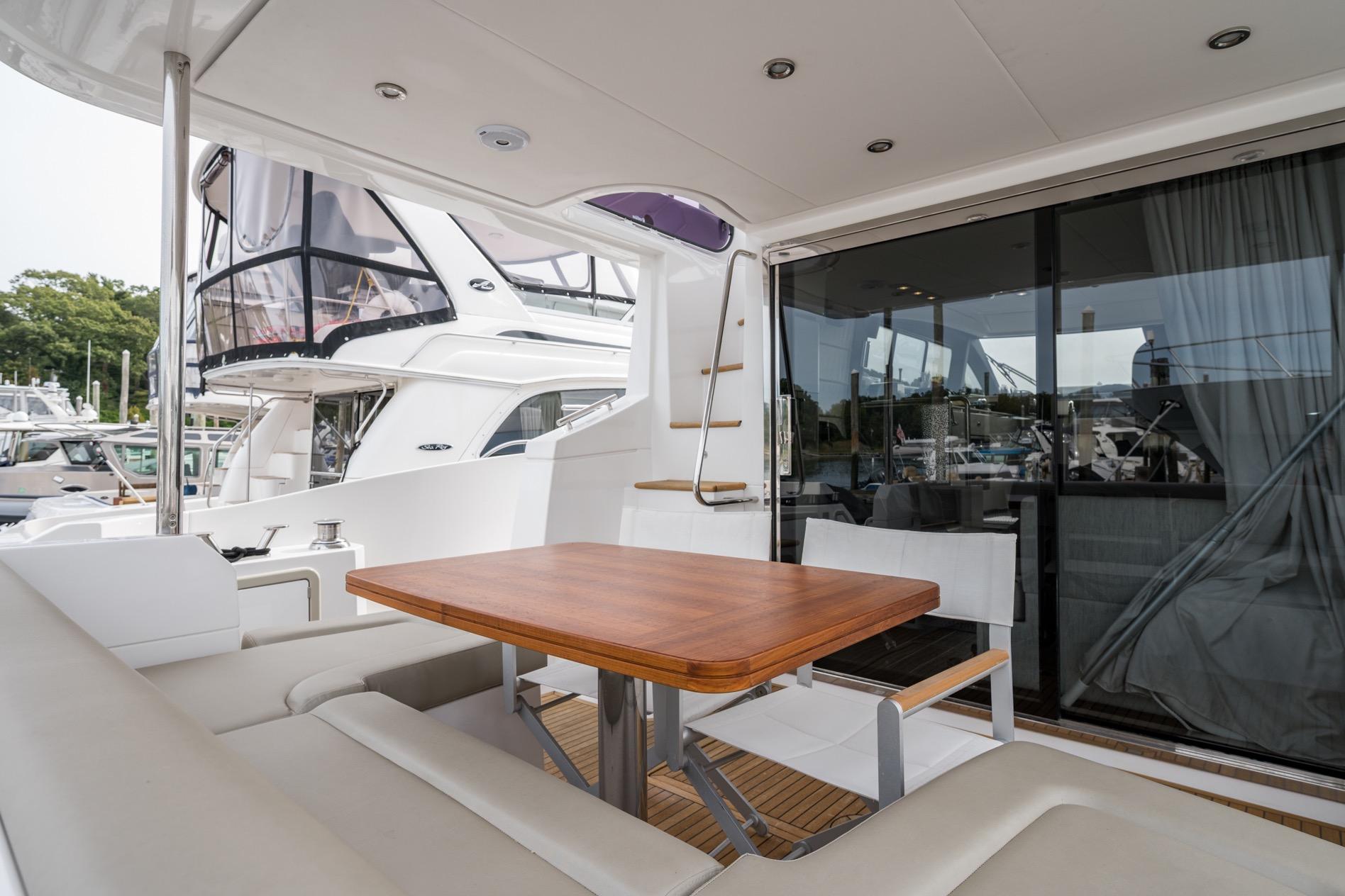Luxurious 2020 Azimut Fly 50 yacht with elegant outdoor seating and wooden table.