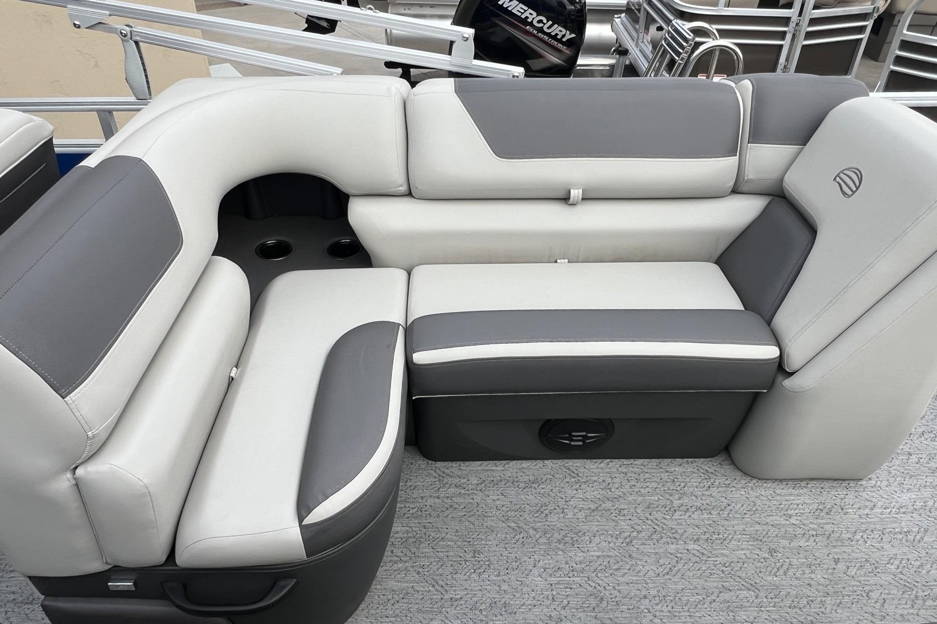 2026 Sun Tracker Fishin' Barge 20 DLX, featuring gray and white cushioned seating.