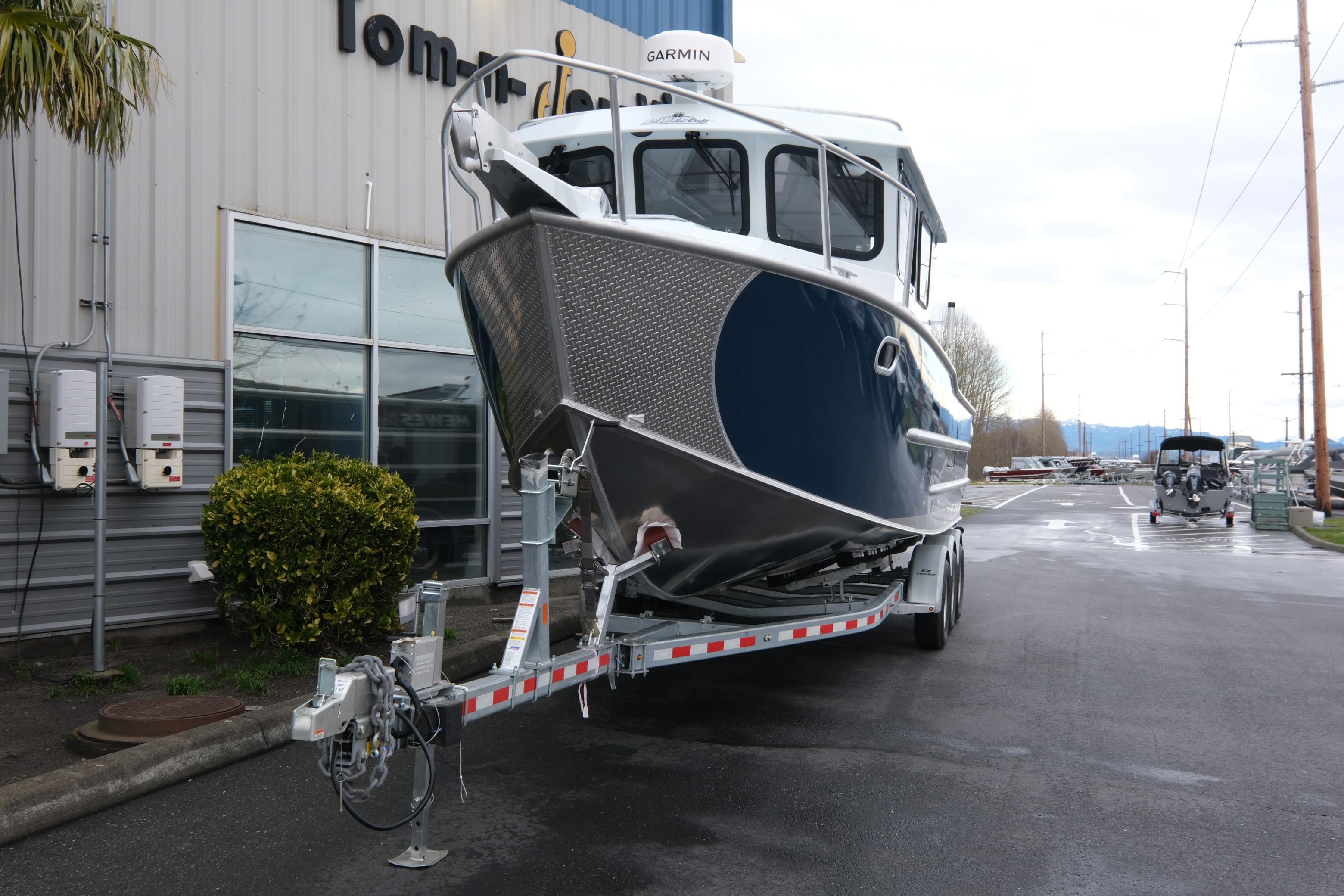 2026 Hewescraft 270 Pacific Explorer boat on trailer outside dealership.