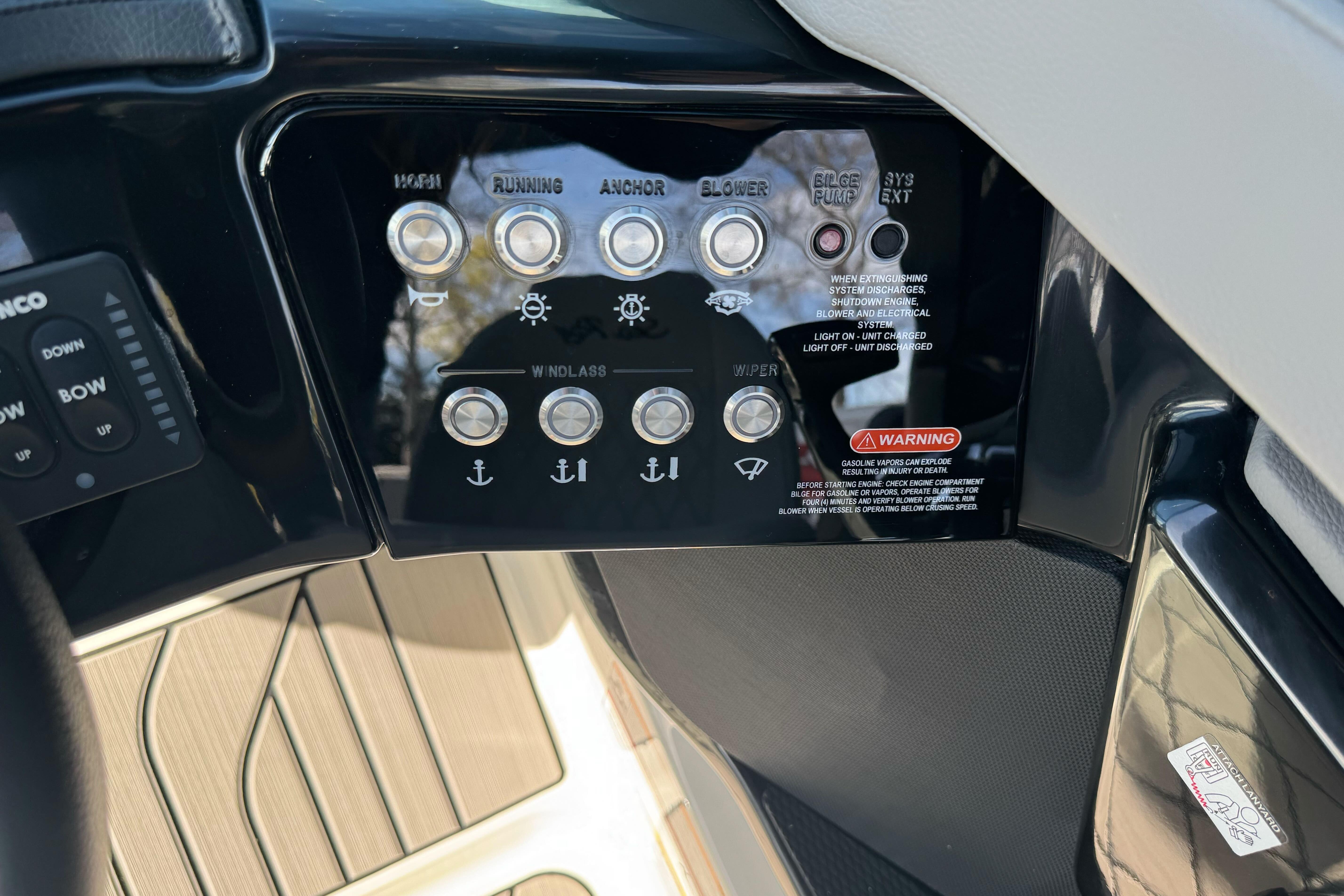 Control panel of 2026 Sea Ray SLX 260 boat with various switches and warning labels.