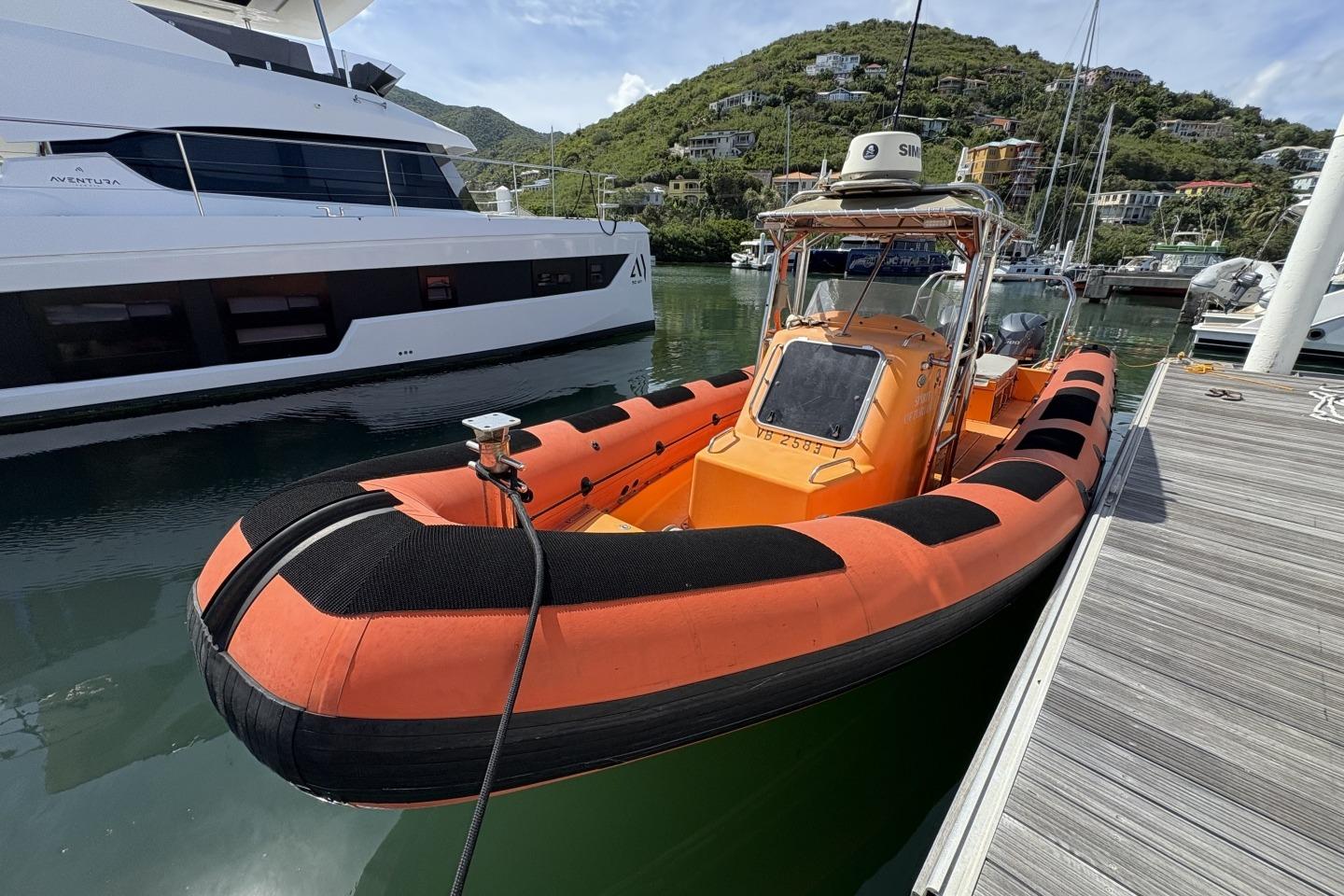 Orange Parker 1000 Baltic boat docked beside a luxury yacht, 2018 model.