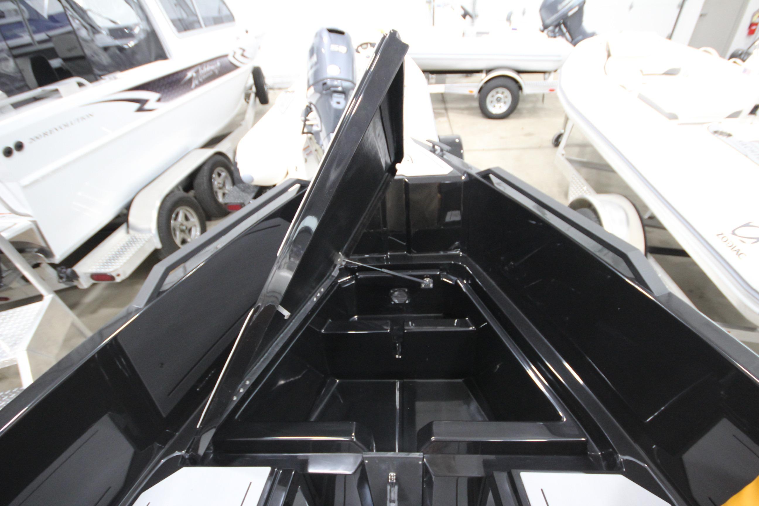 Open storage compartment on Iron 767 boat, showcasing sleek black interior design.