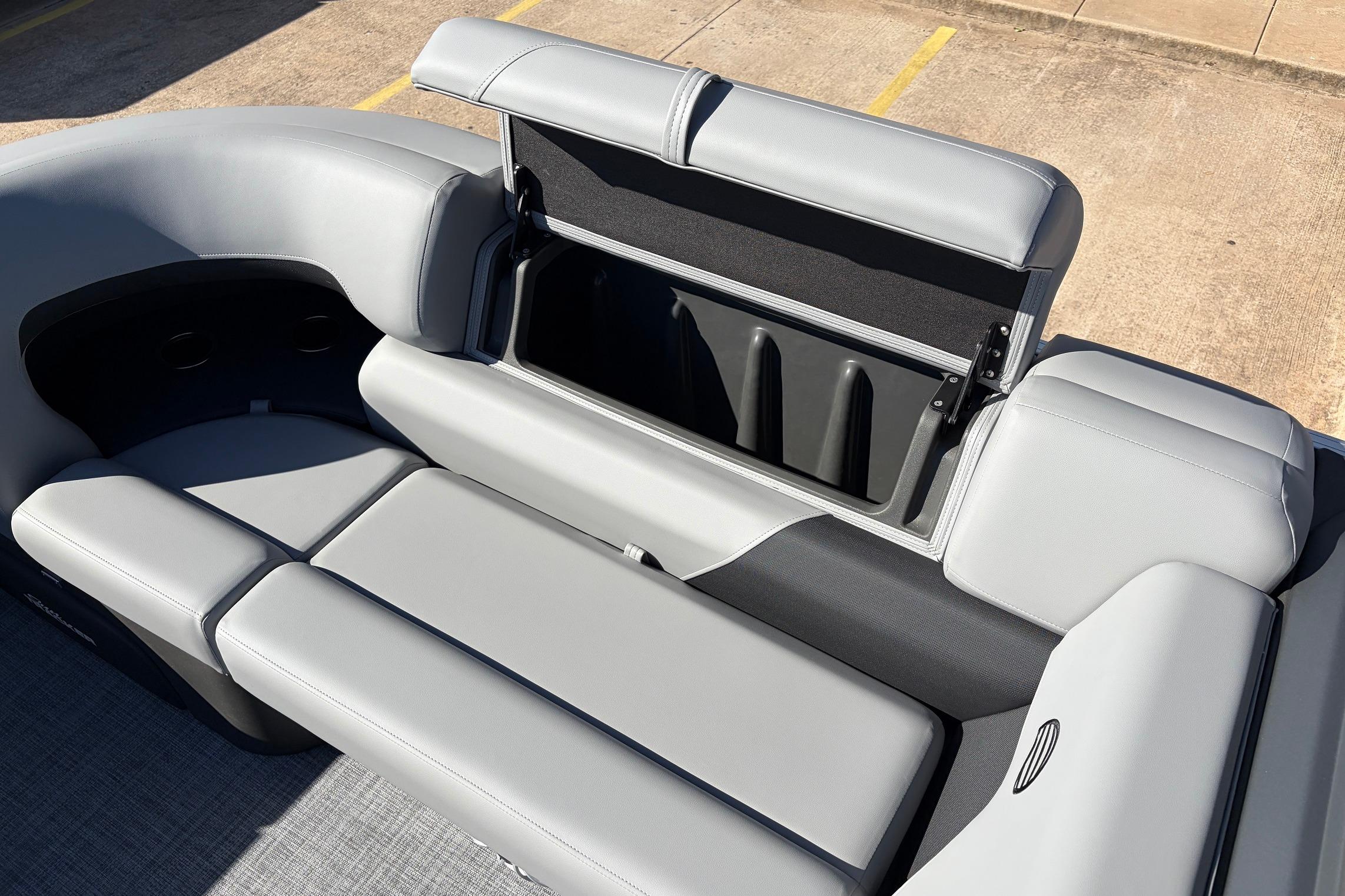 2026 Sun Tracker Party Barge 22 RF XP3 with open storage compartment and gray seating.