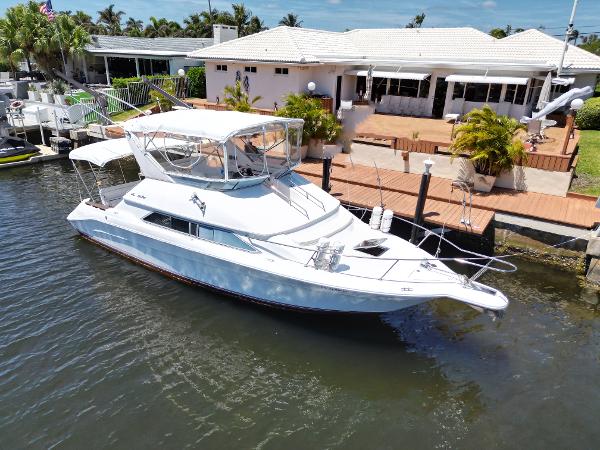 1992 Sea Ray 350 Express Bridge docked near waterfront home.