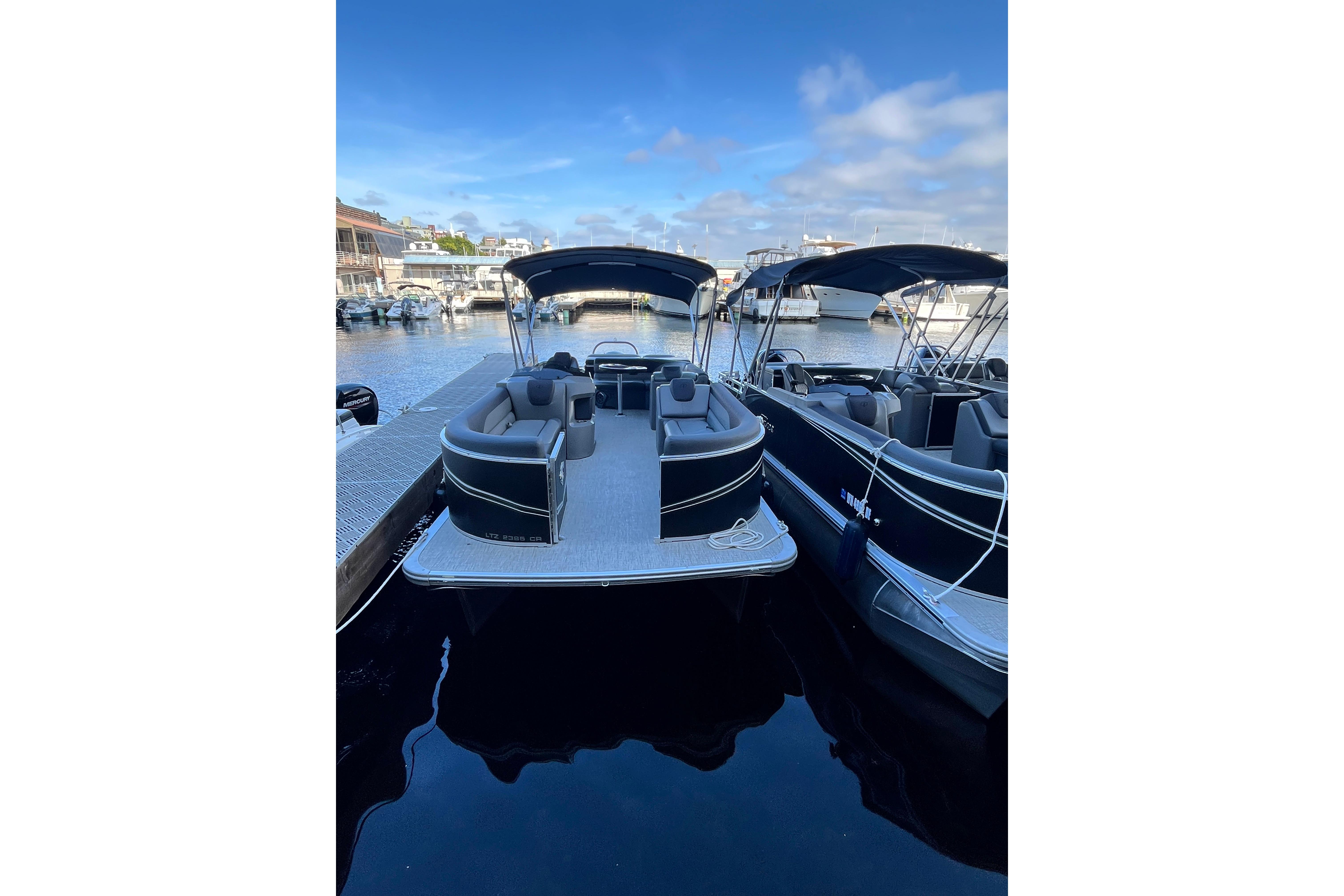 2023 Tahoe Pontoon LTZ Cruise docked at marina under clear blue sky.