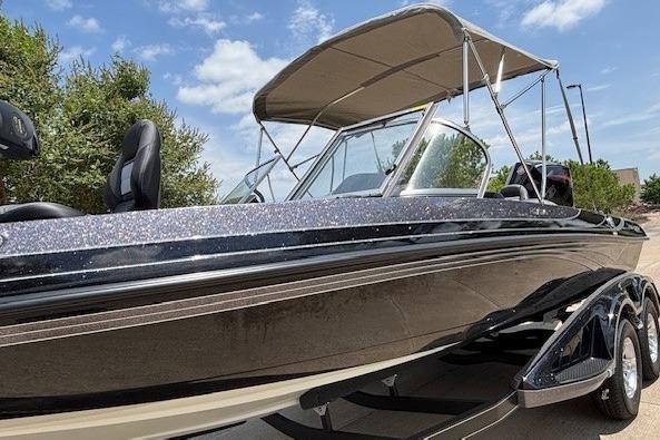 2026 Ranger 212LS boat with canopy, sleek design, parked outdoors under blue sky.