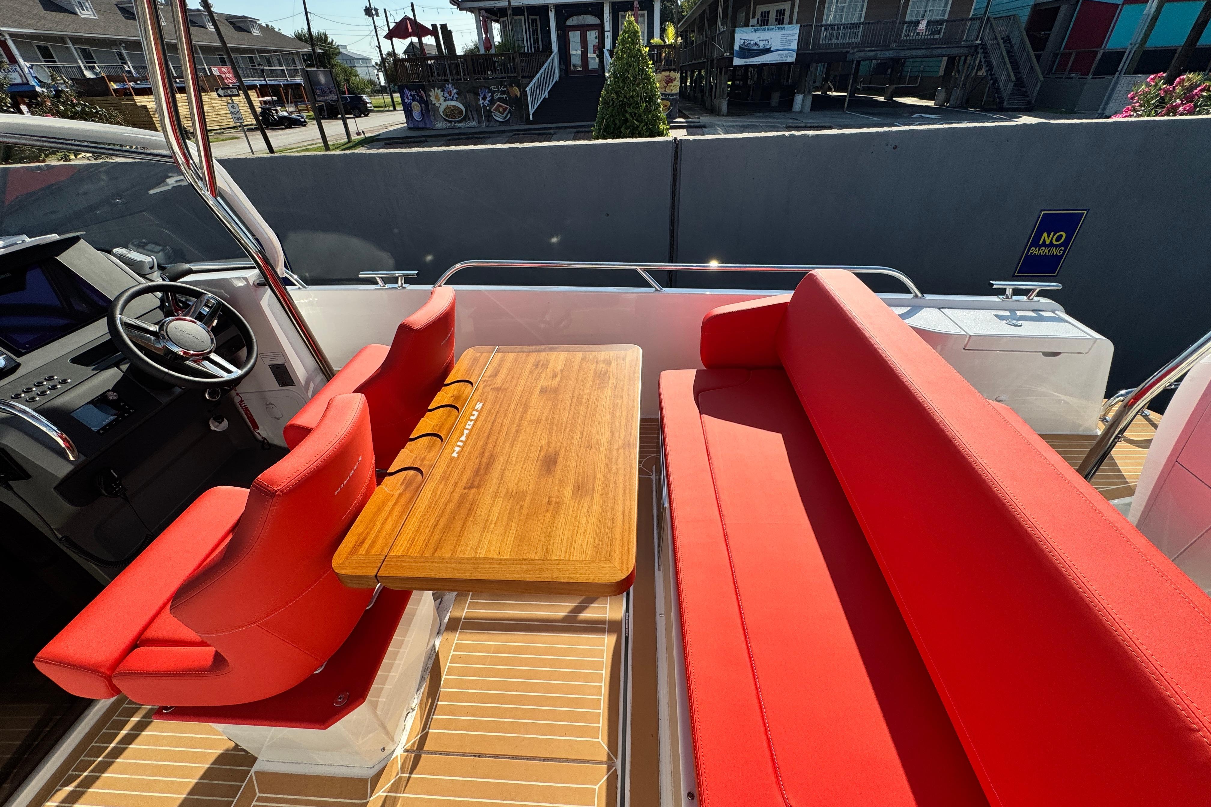 Red seating and wooden table on 2025 Nimbus Tender 8 boat deck.