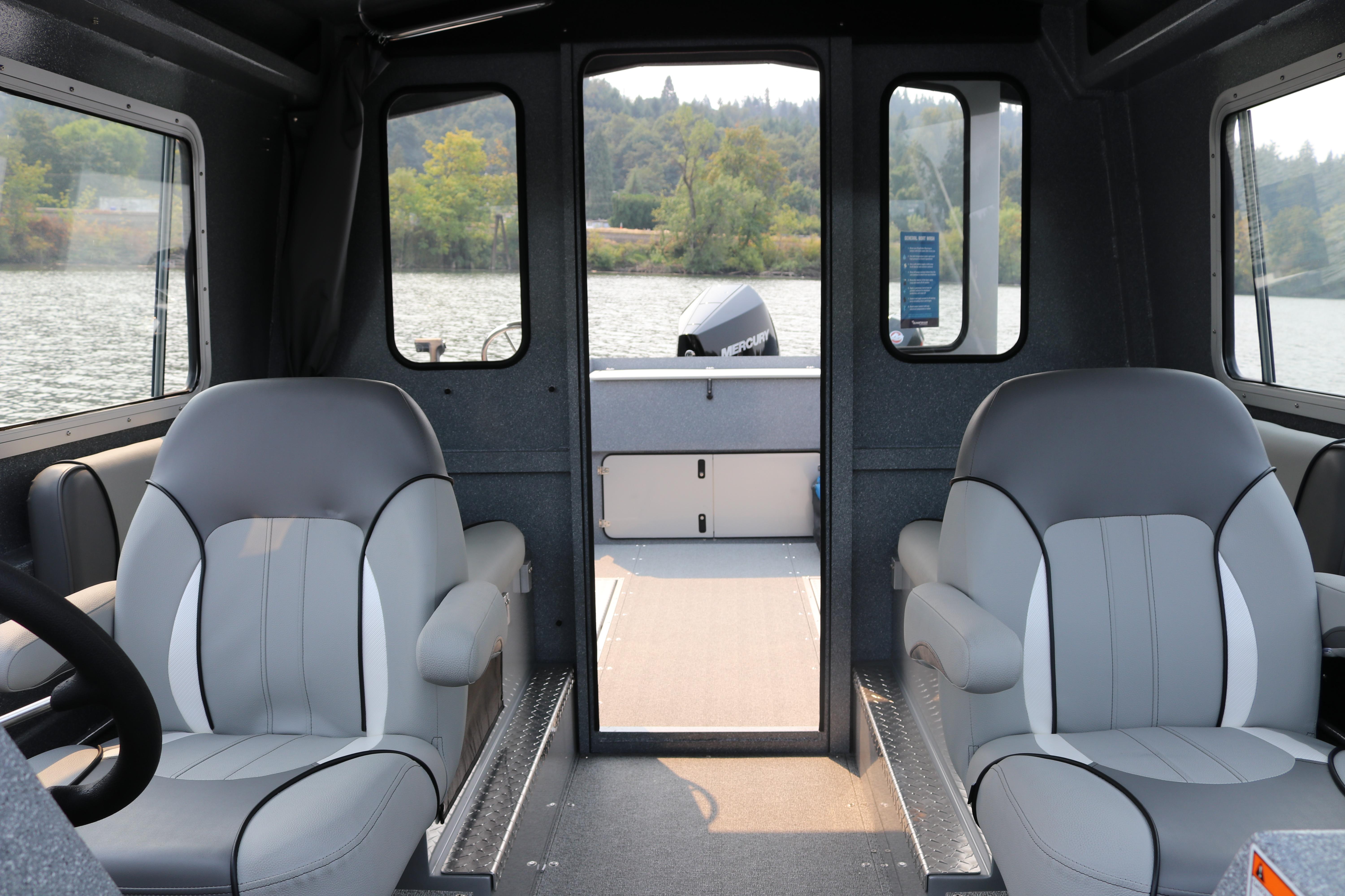 Interior of 2026 KingFisher 2425 Escape HT boat with comfortable seating and scenic water view.