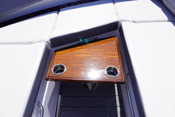 Luxury seating area on 2020 Cruisers Yachts 38 GLS OB with wooden table and cup holders.