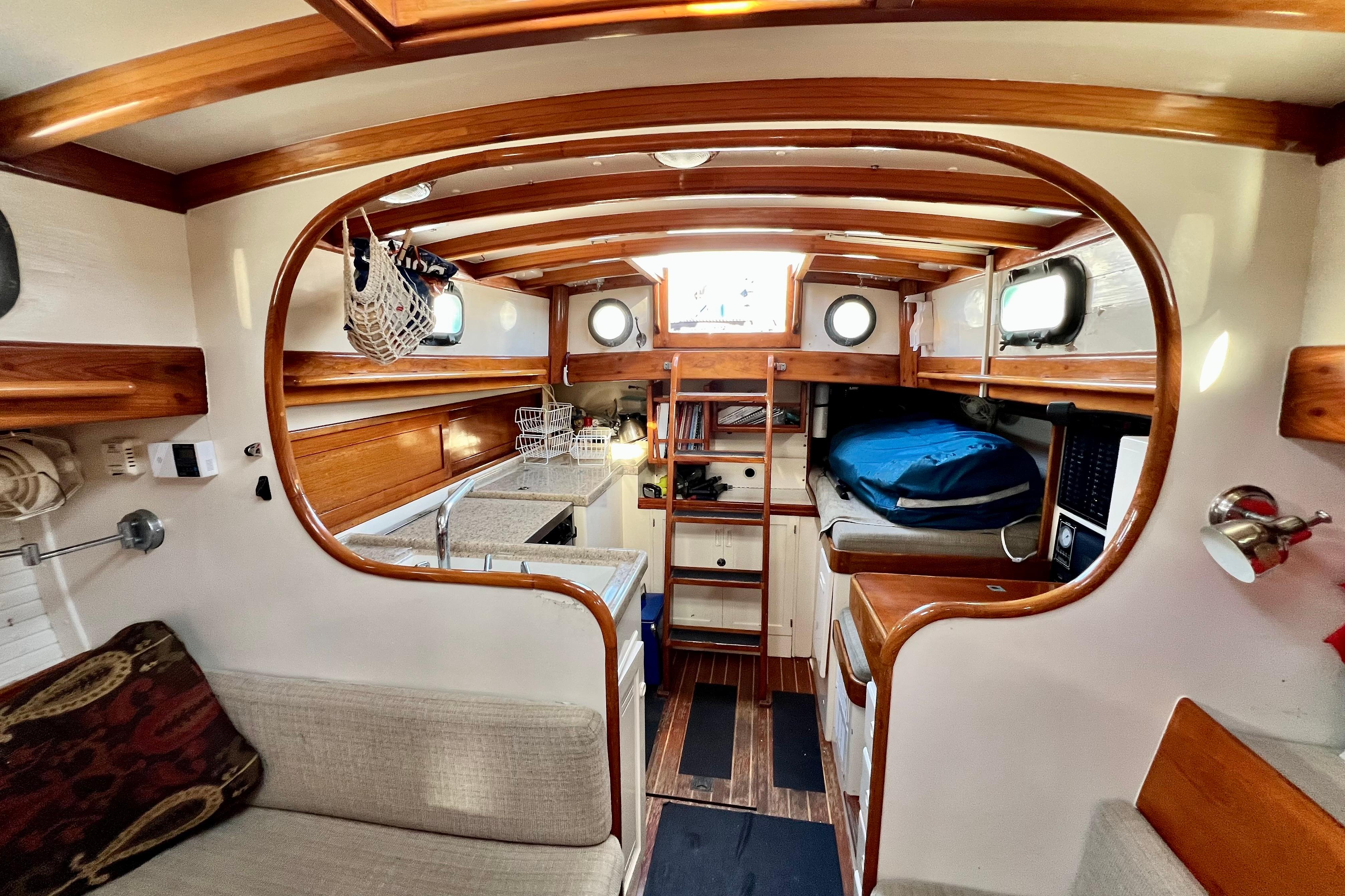 Interior of a 1975 Cape George 36 sailboat with wooden accents and cozy seating.