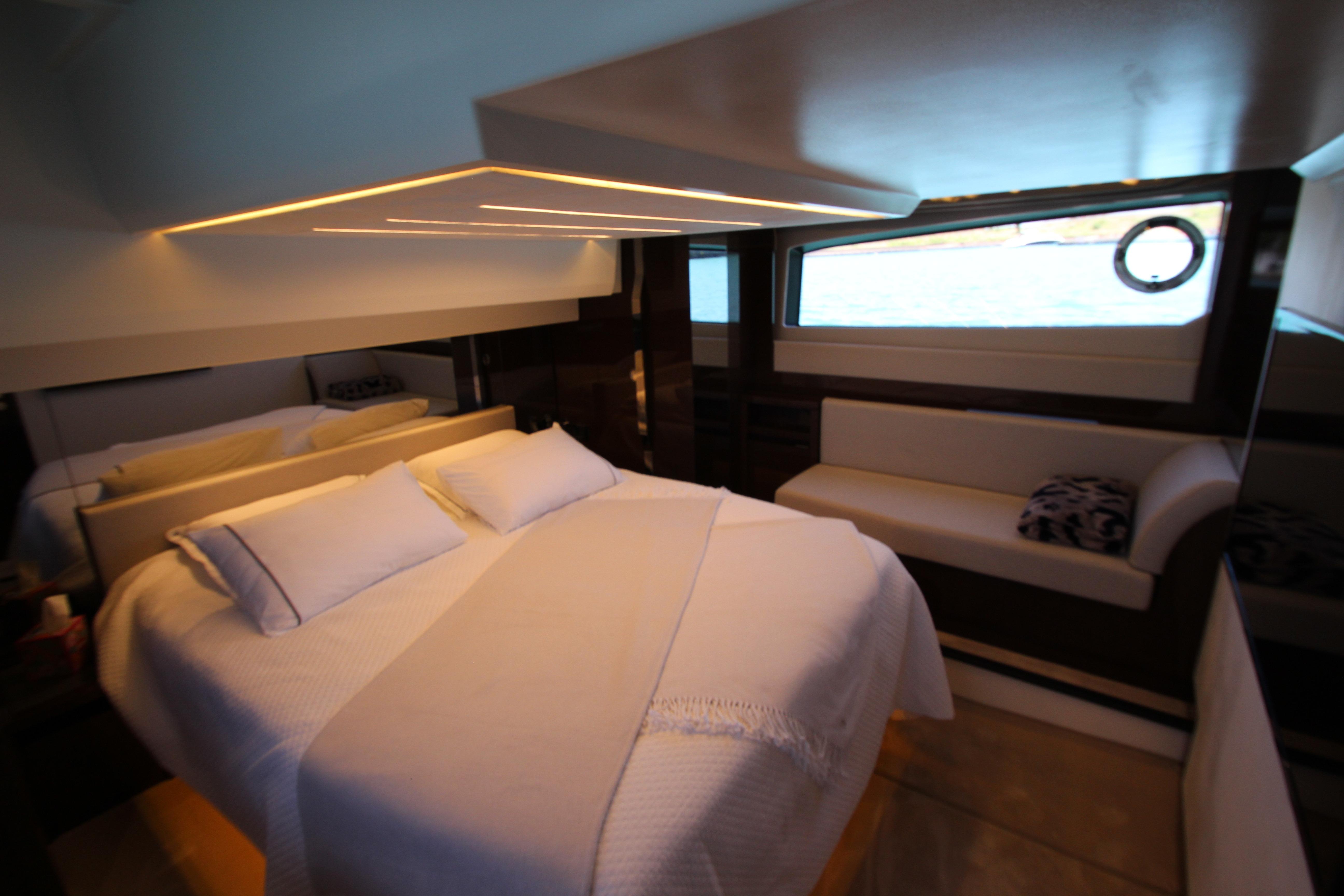 Luxurious bedroom interior of 2022 Prestige 520 yacht with modern design and ambient lighting.