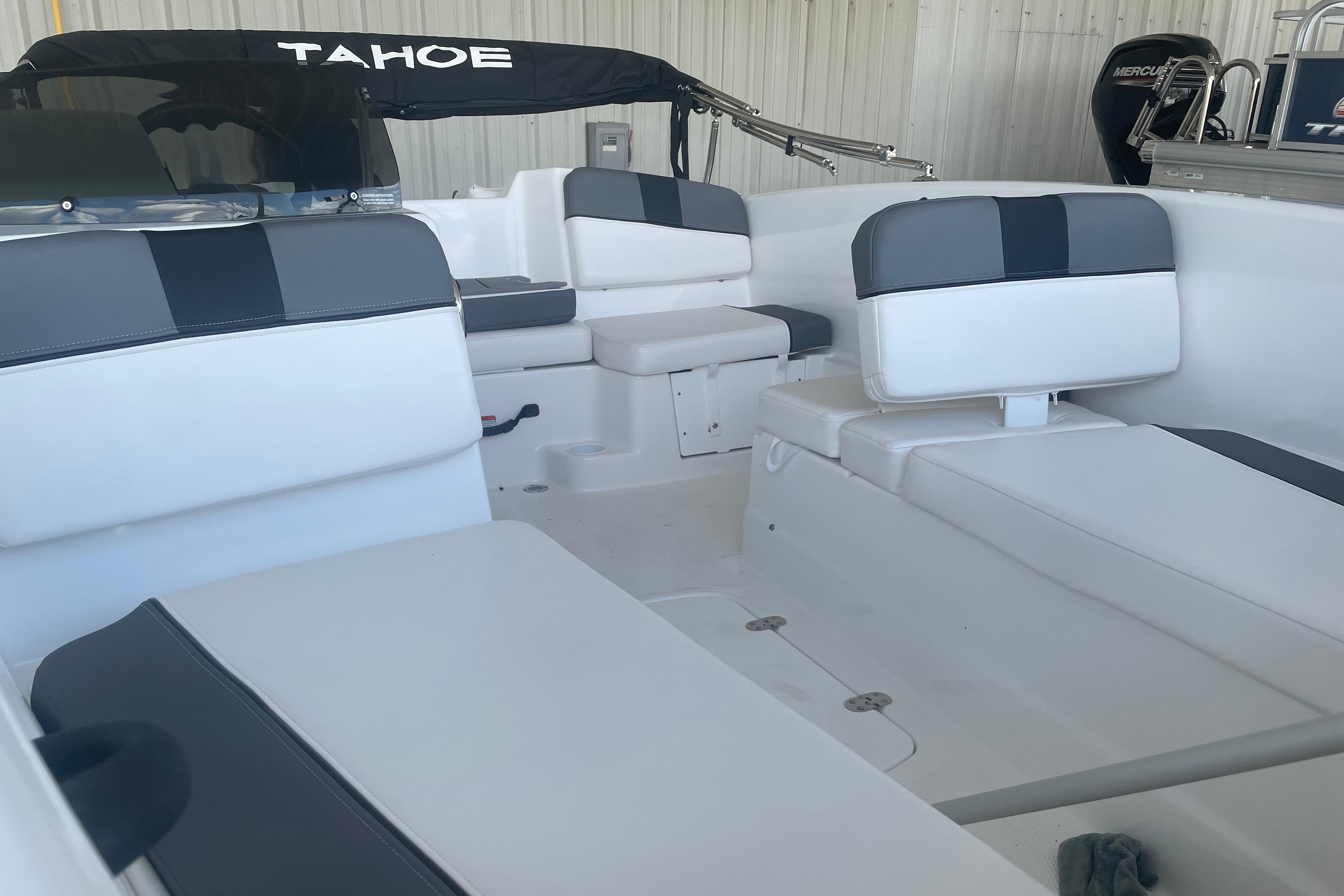 2026 Tahoe T16 boat interior with white and gray seating, under a covered area.