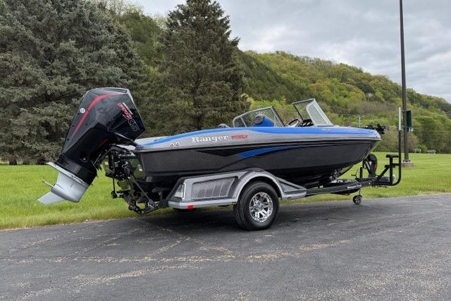 2025 Ranger 1850MS boat on trailer, parked outdoors with lush green background.