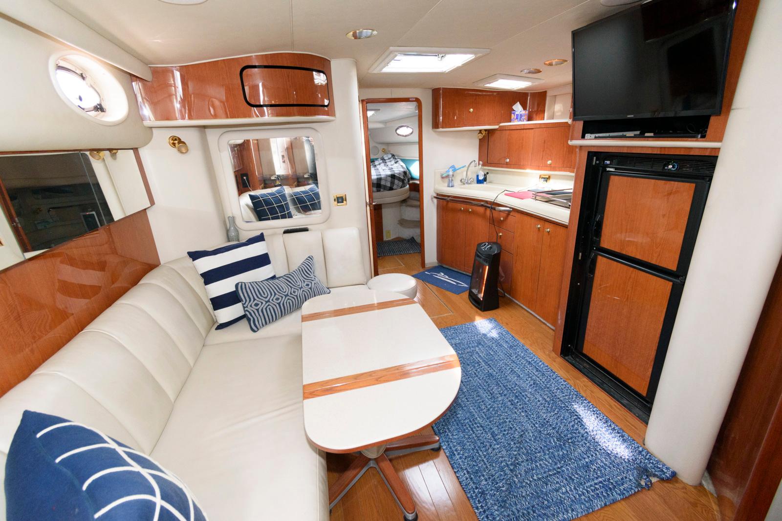 Interior of 1998 Sea Ray 450 Sundancer yacht with modern furnishings and kitchen area.